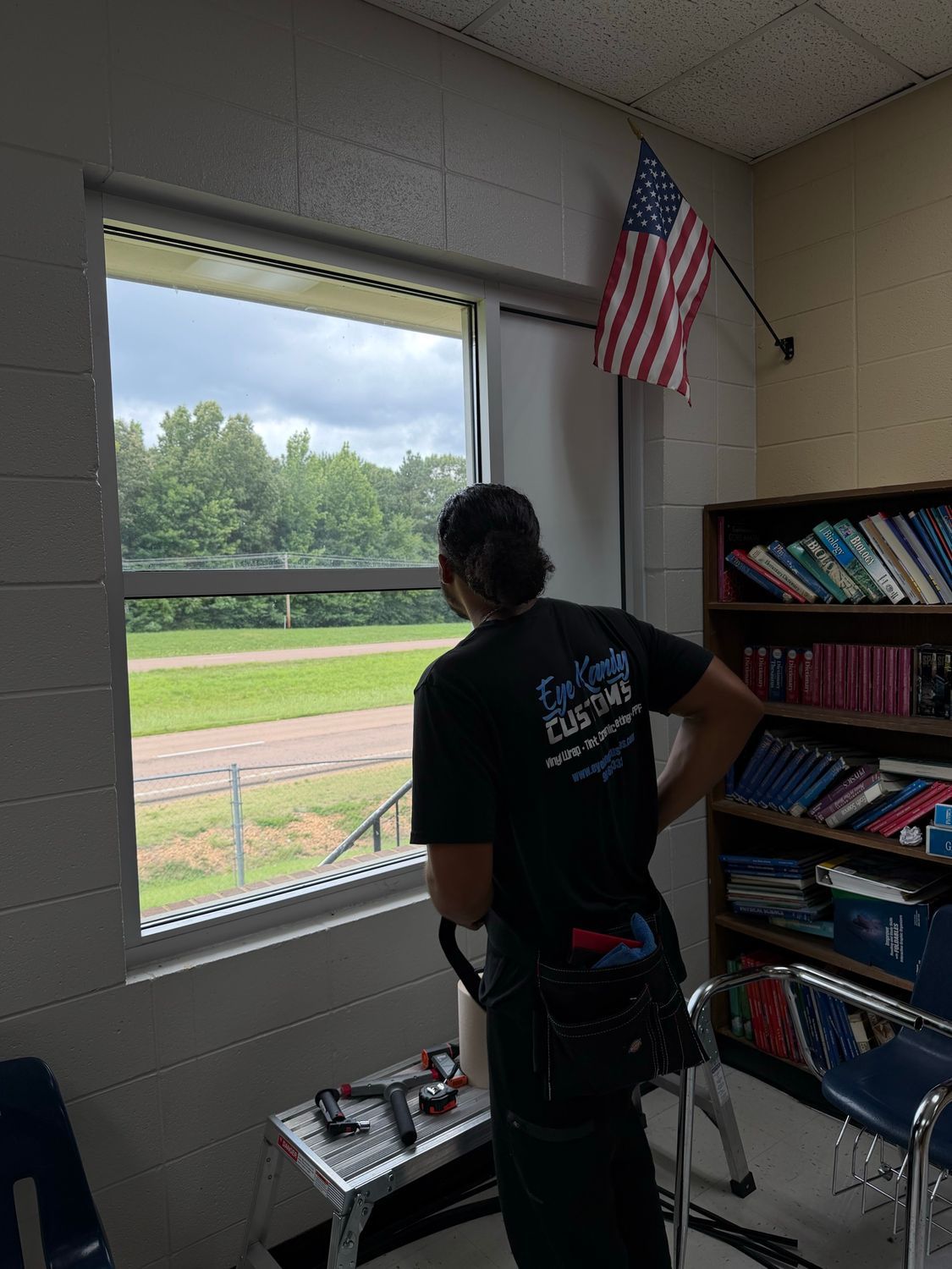 Installer preparing a classroom window for tint at H.W. Byers School