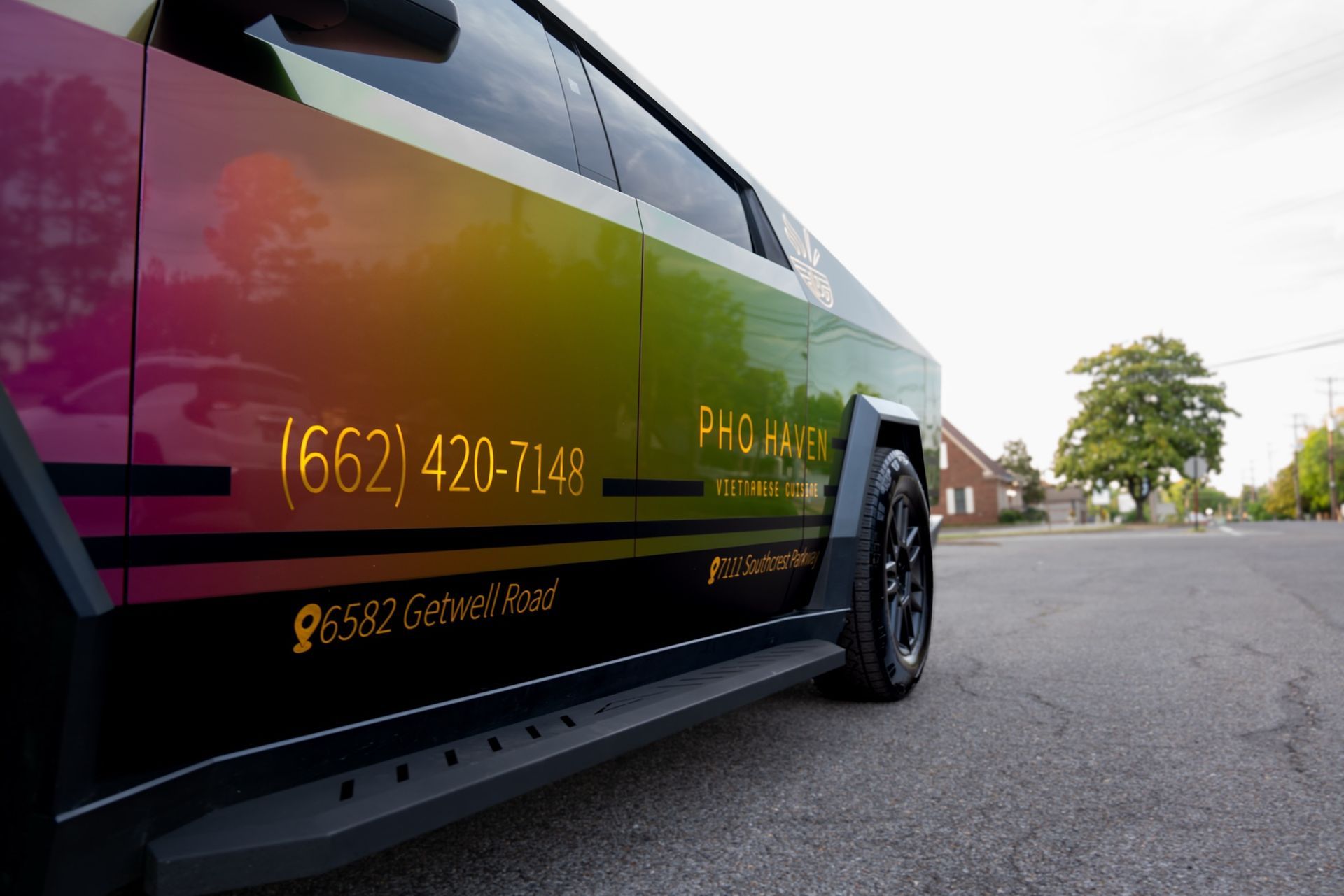 Gold chrome phone number and address graphics on the Pho Haven Cybertruck door