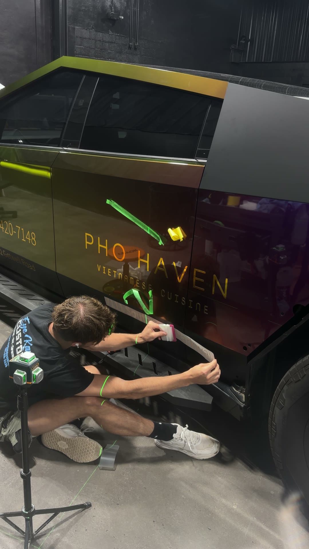 Eye Kandy Customs installer applying gold chrome Pho Haven lettering