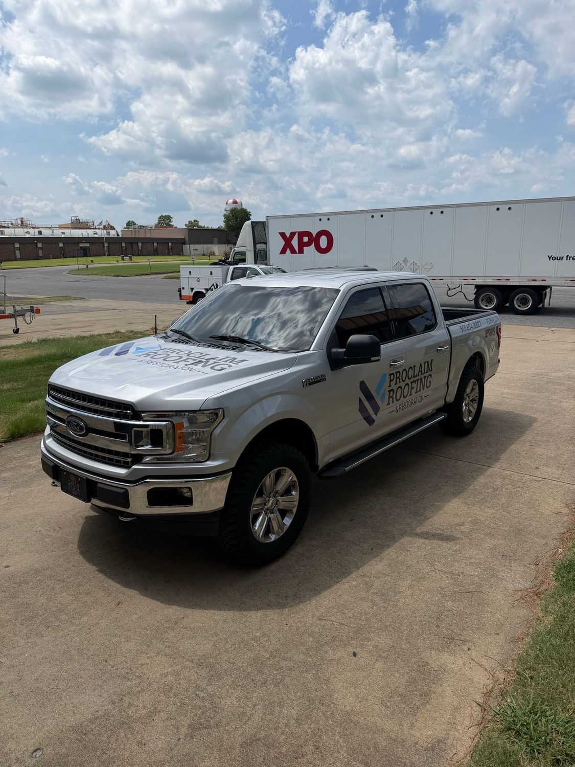 Front three-quarter view of the Proclaim Roofing truck decals