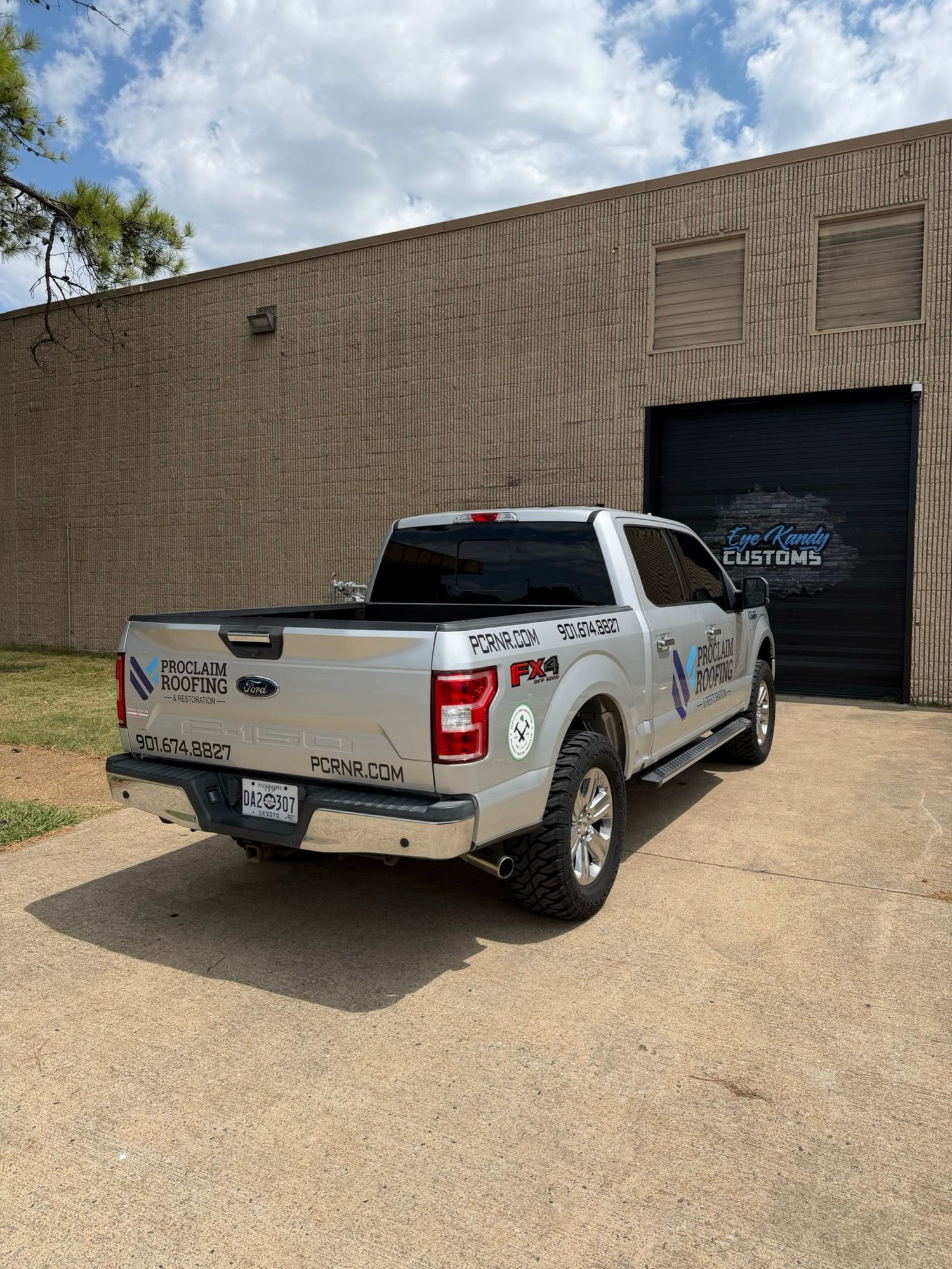 Rear view of the Proclaim Roofing truck decals outside Eye Kandy Customs
