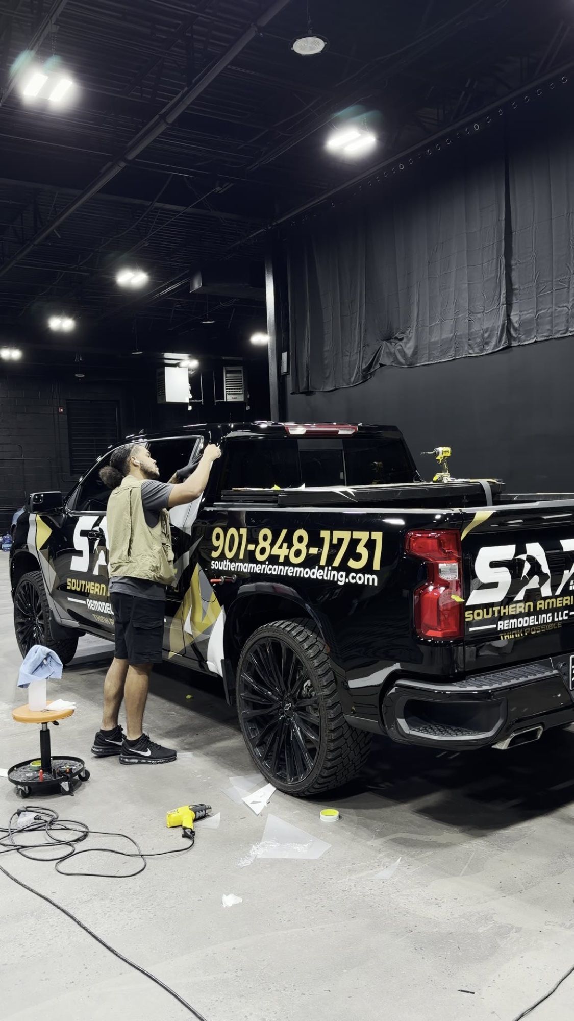 Installer applying custom cut graphics to the Southern American Remodeling truck