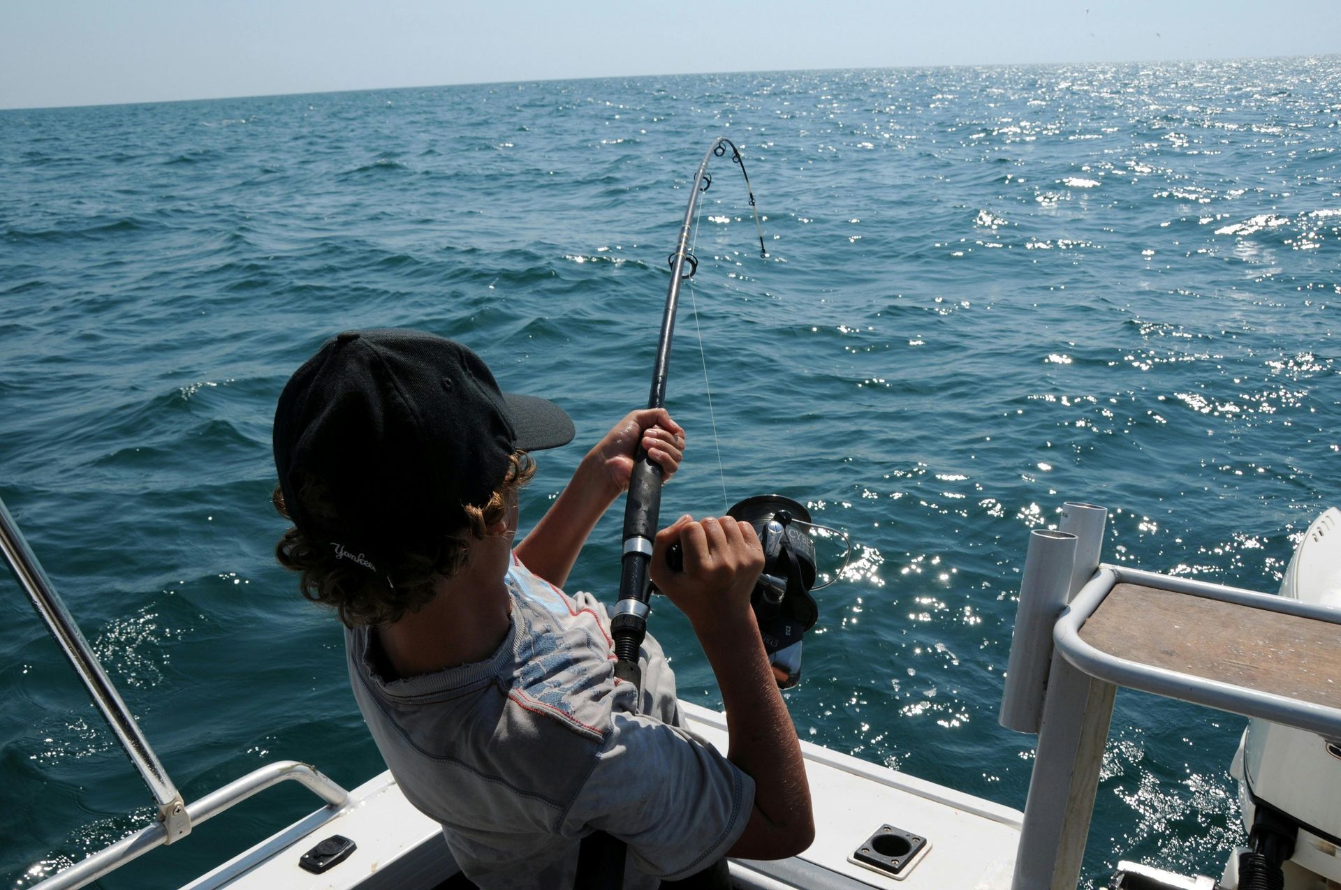 Un hombre está pescando en un barco en el océano.