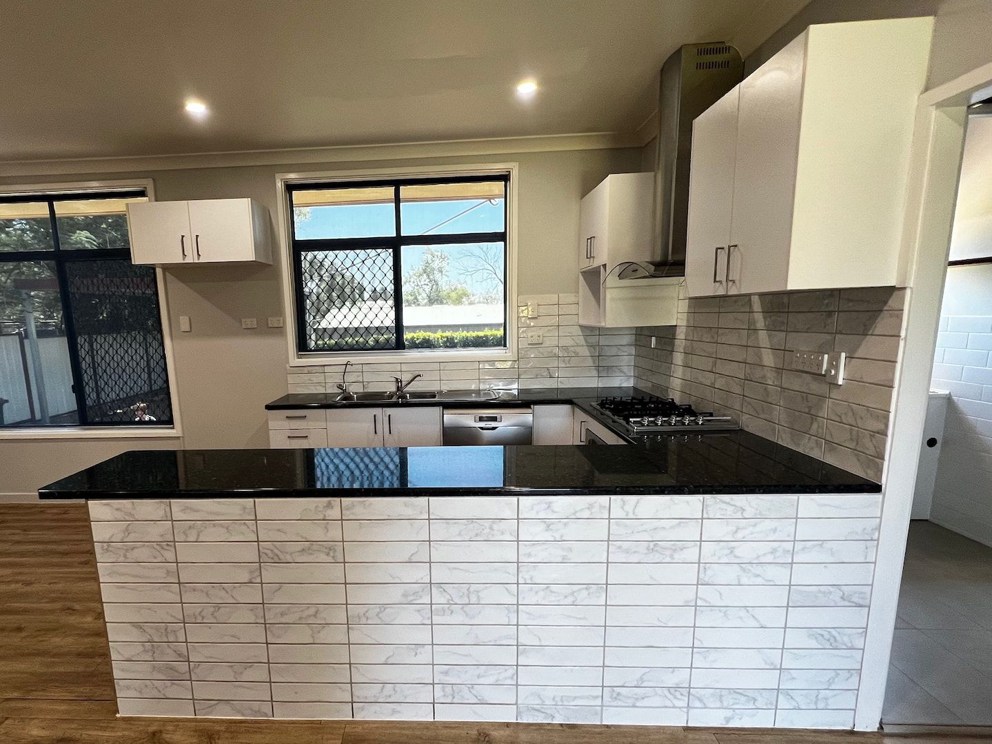 A Kitchen With White Cabinets And A Black Counter Top — Miss Bright Cleaning Services In Mount Isa City, Qld