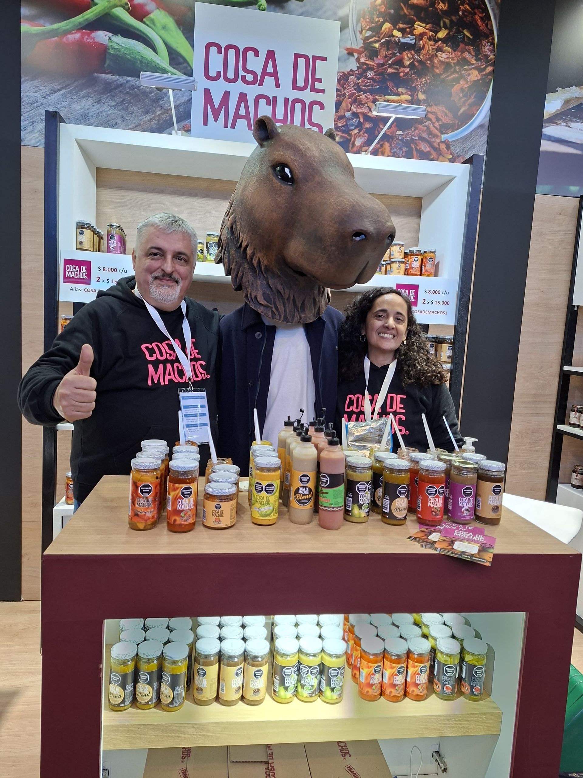 Puesto de venta con una cabeza de capibara en exhibición y frascos de salsas en estantes