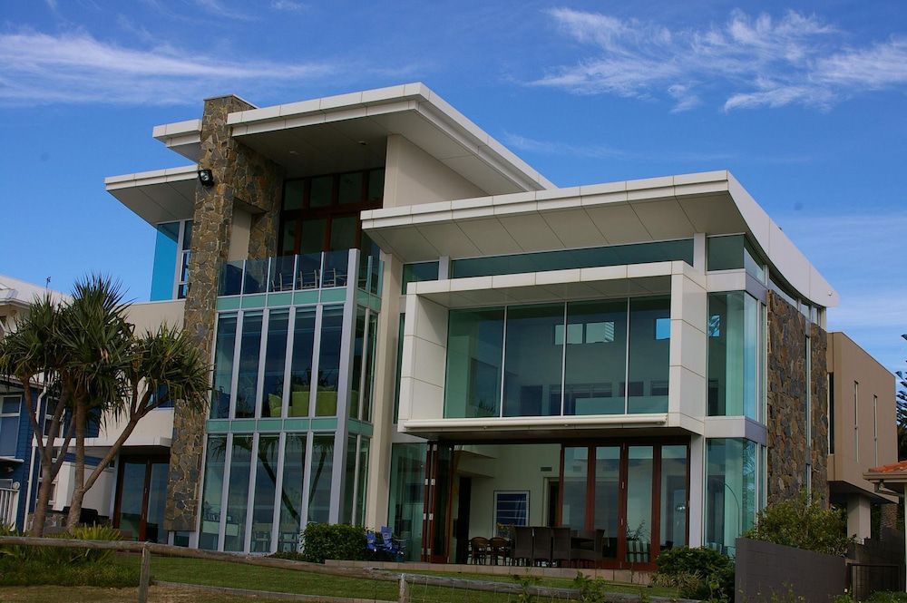 A Large House With a Lot of Windows and a Blue Sky in the Background — Ron Nickel Roofing in Tweed Heads South, NSW