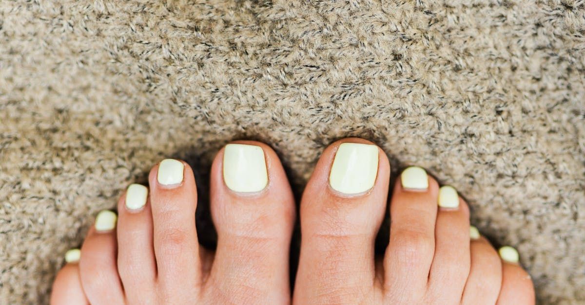 A close up of a woman 's feet with white toenails.