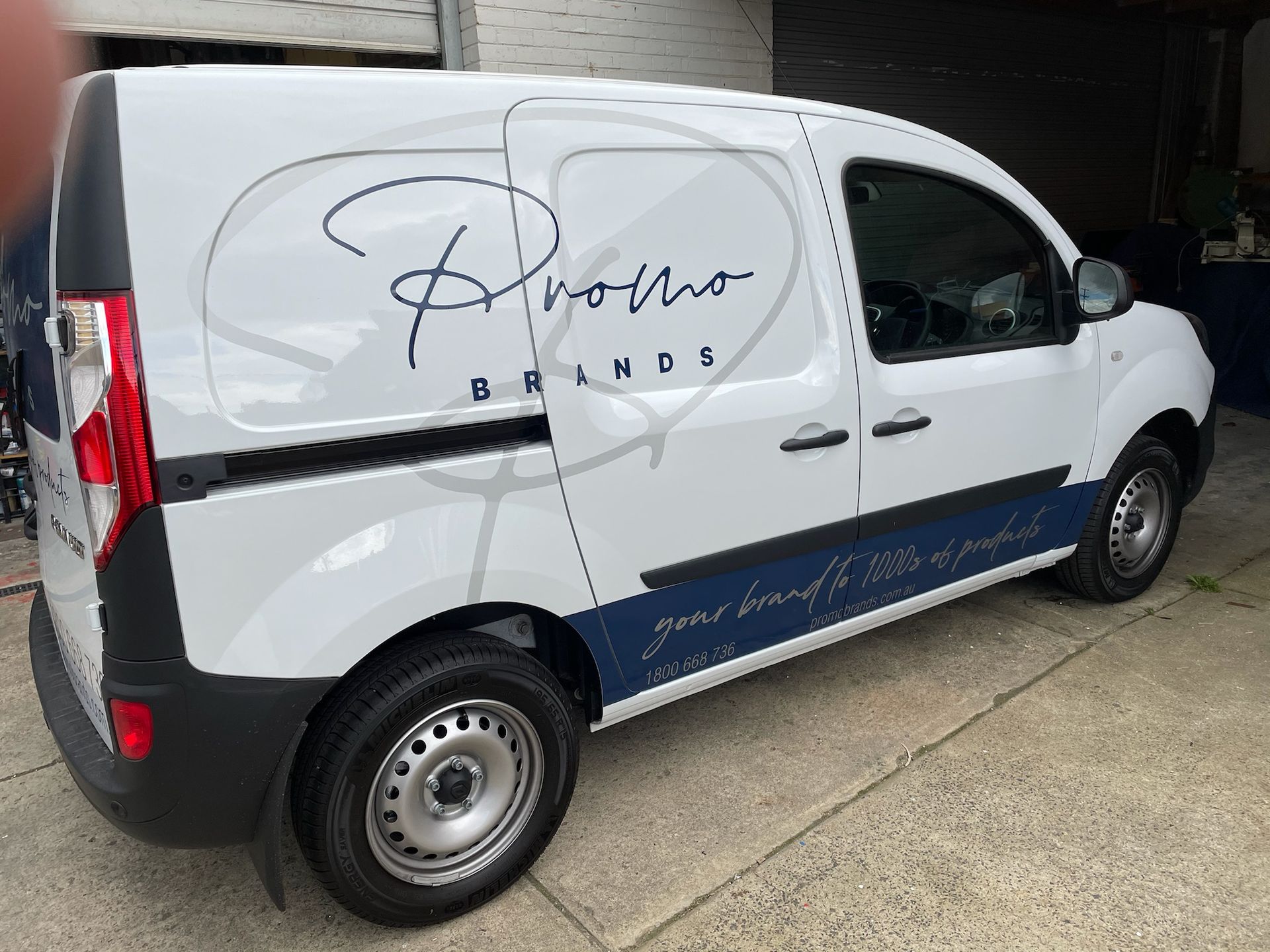 A white van is parked in front of a building.