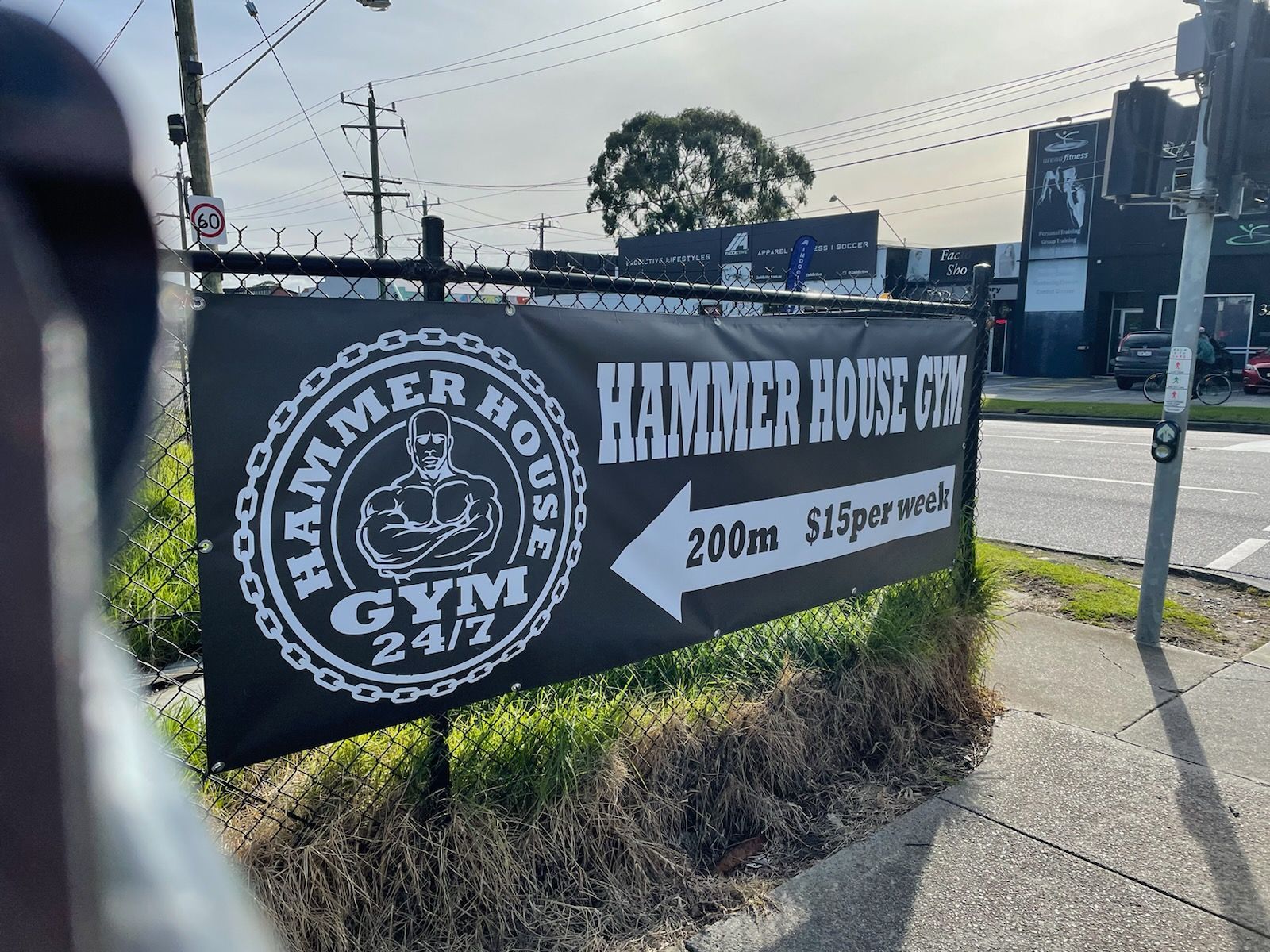 A sign for the hammer house gym is on the side of the road