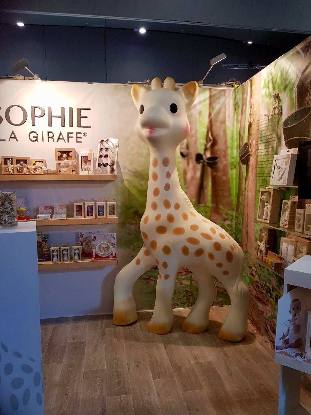A large statue of a giraffe is standing in a store.