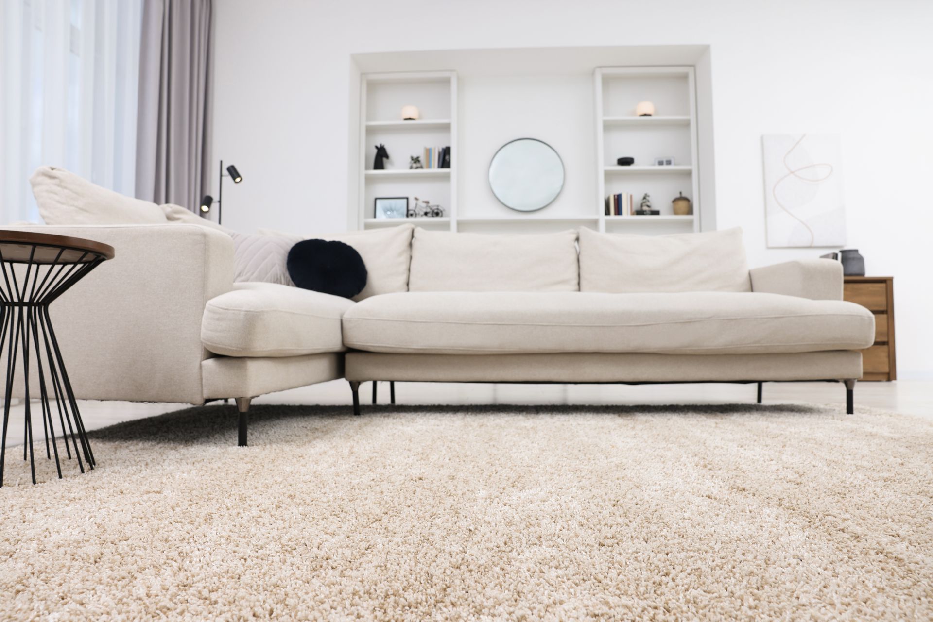 A living room with a white couch and a white rug.