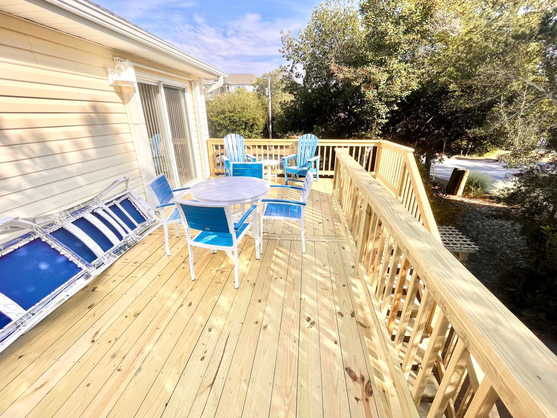 A large wooden deck with a table and chairs on it.