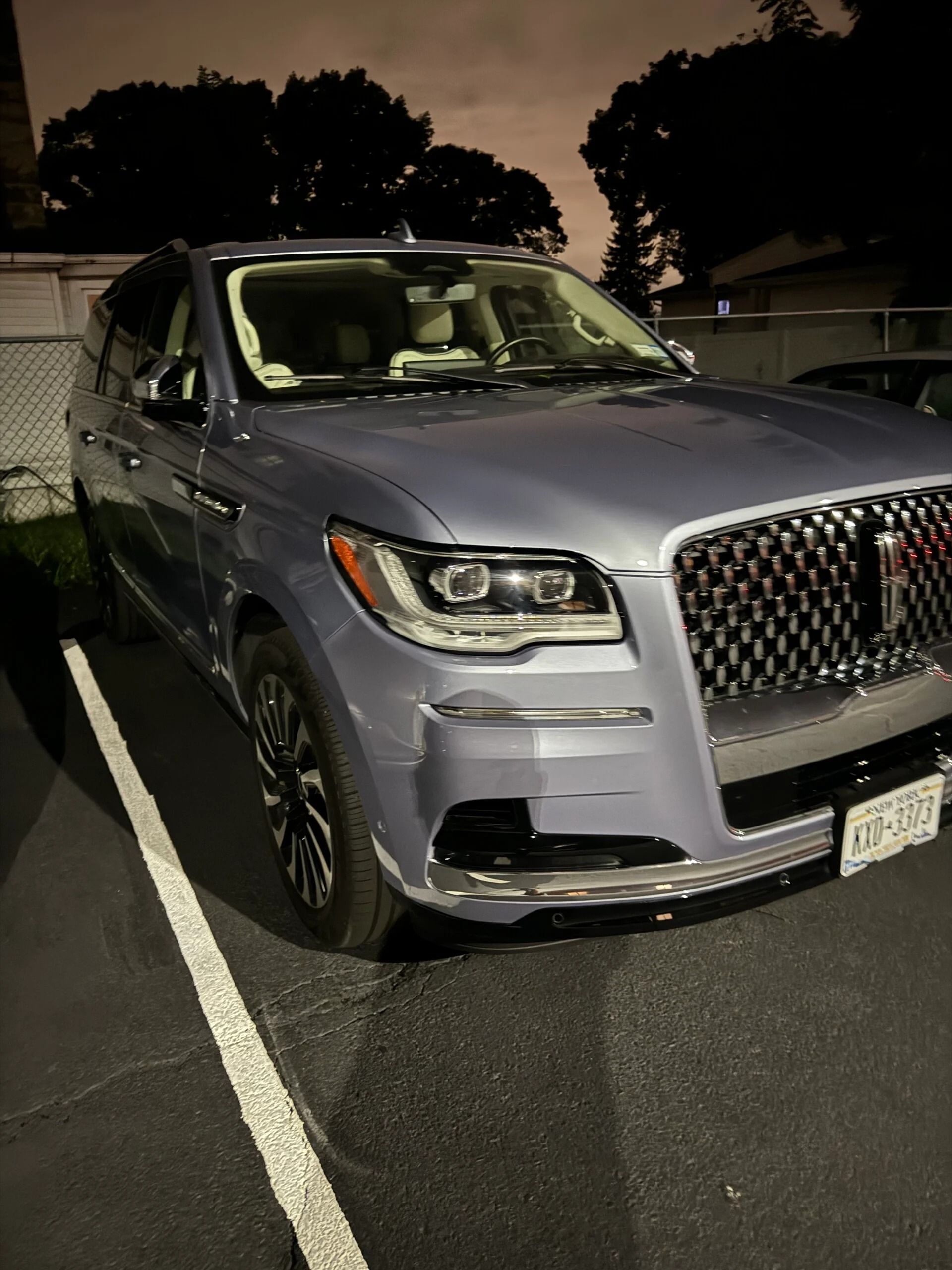 Silver SUV parked in a lot at night, viewed from the front-left angle.