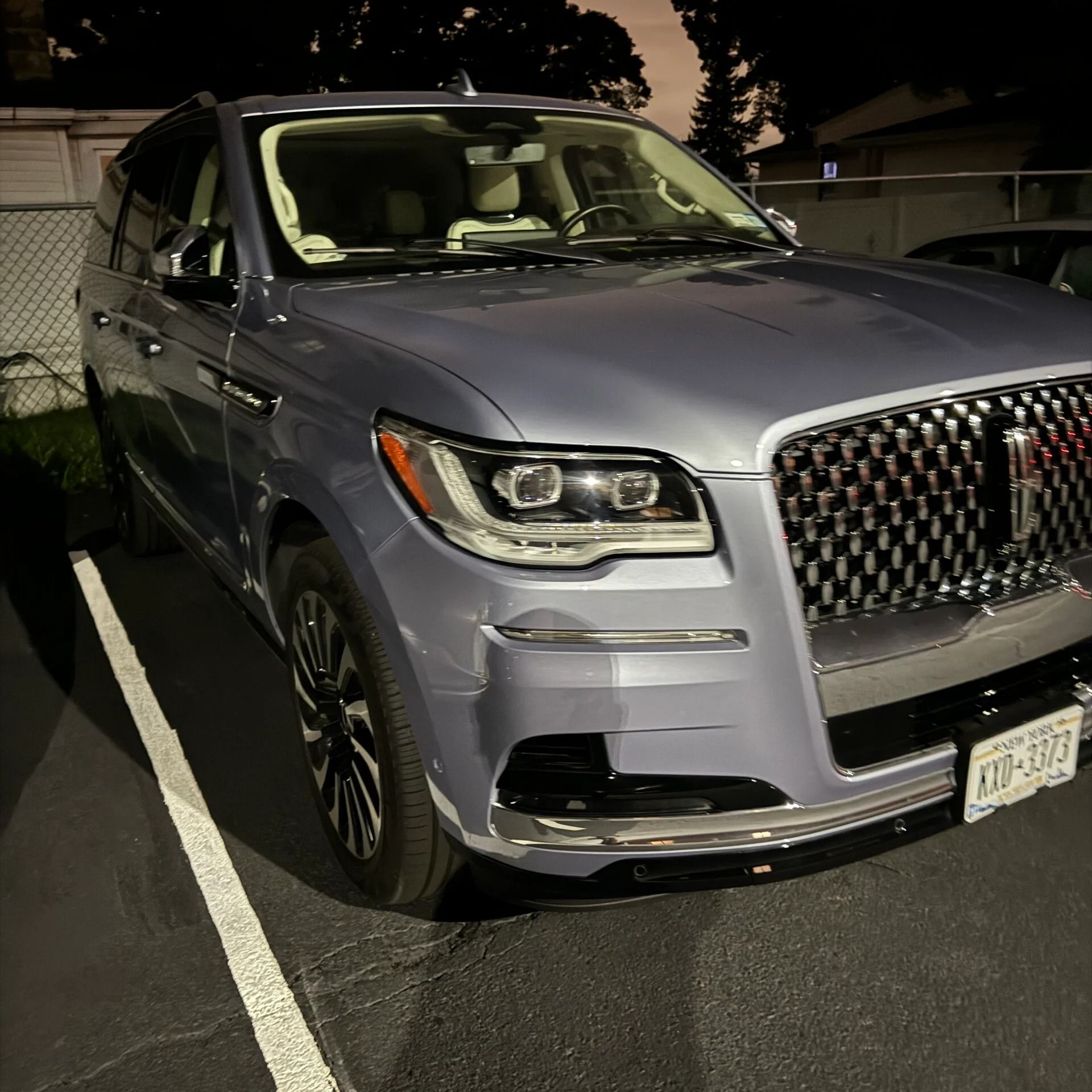 Silver SUV parked at night in a marked parking space, front-left view