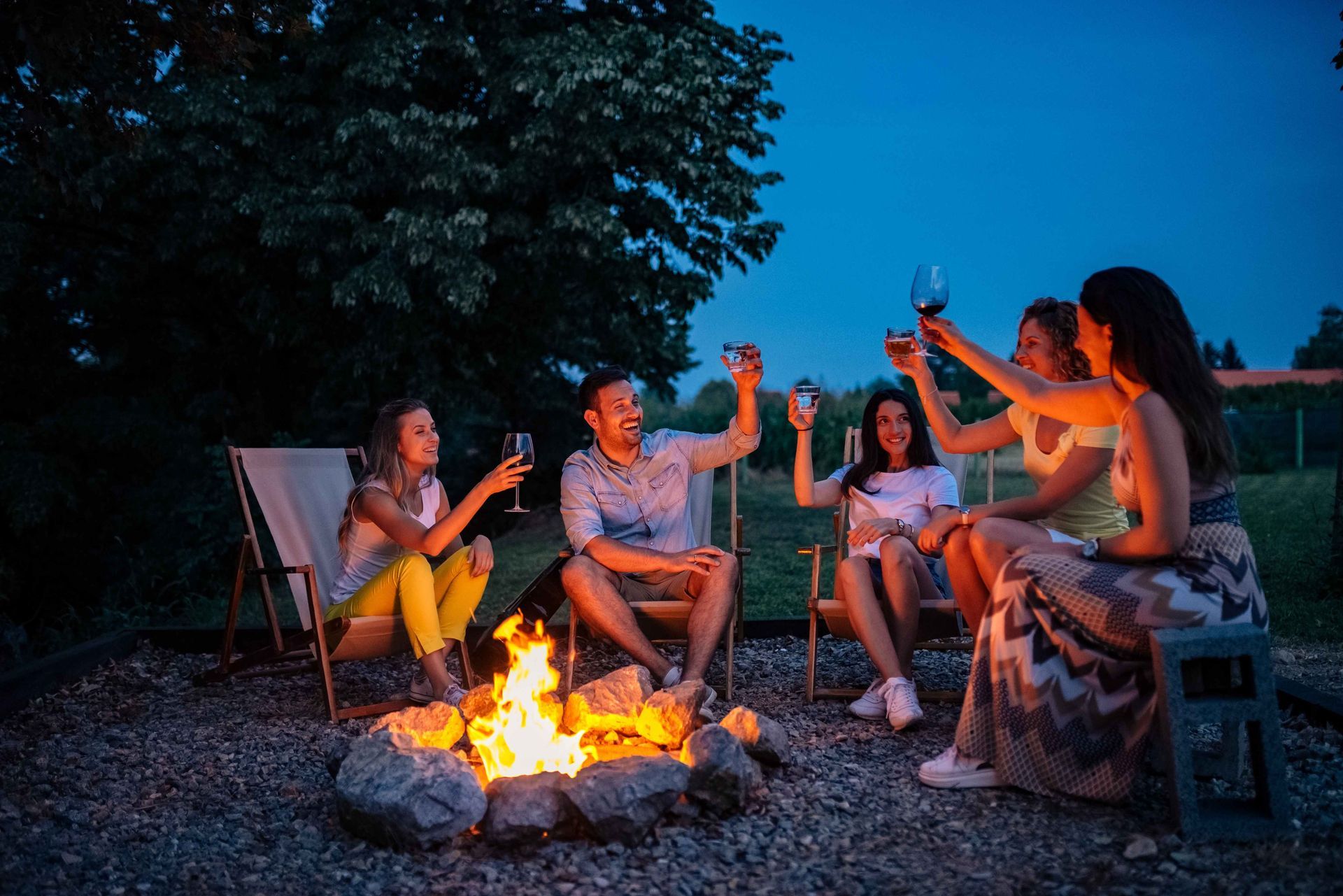Friends enjoying a new fire pit in a yard