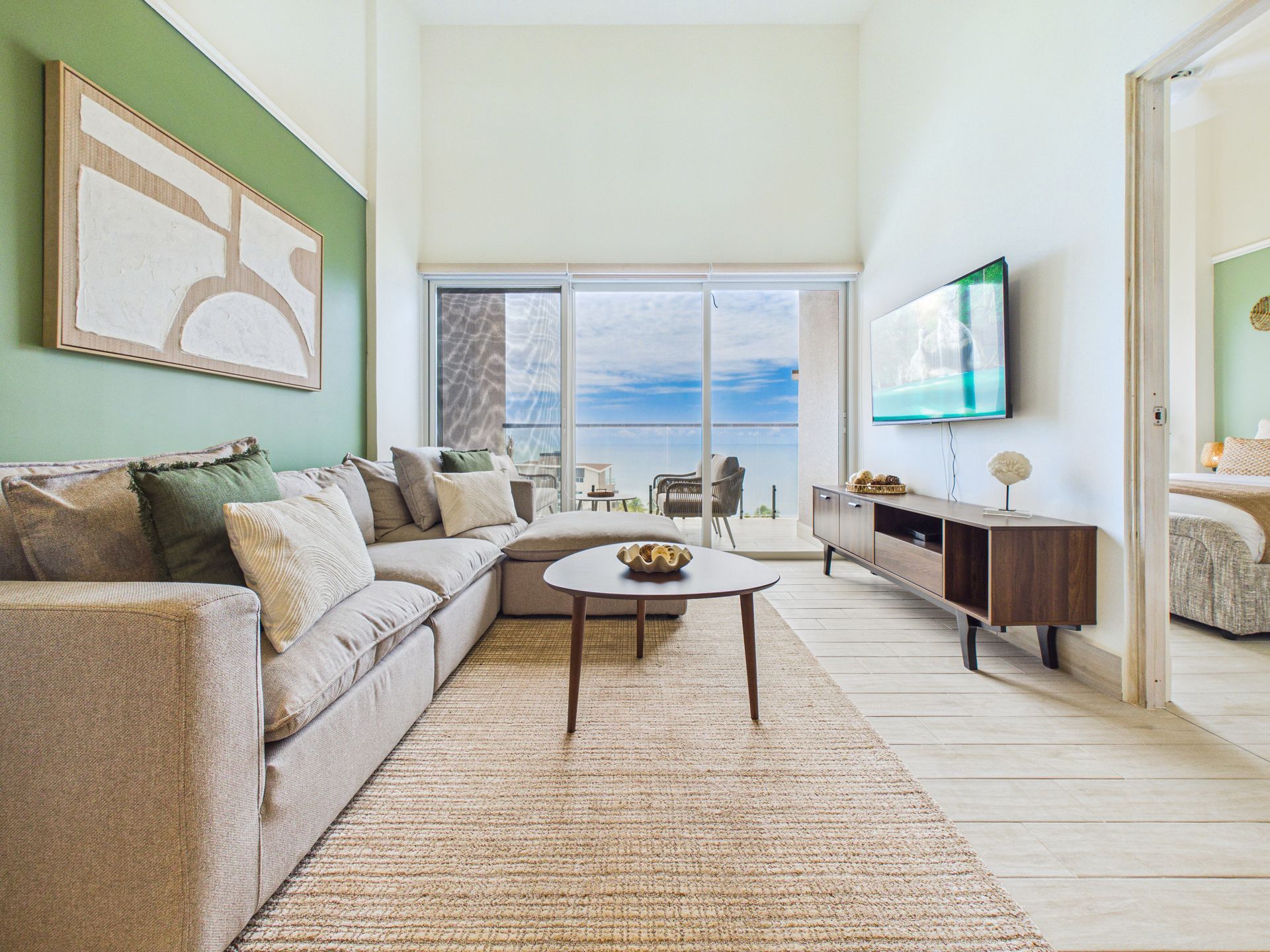 Sala de apartamento en Olas 4, Playa Caracol, con sofá seccional y vista al Océano Pacífico — listing de Relocation Panama Real Estate.