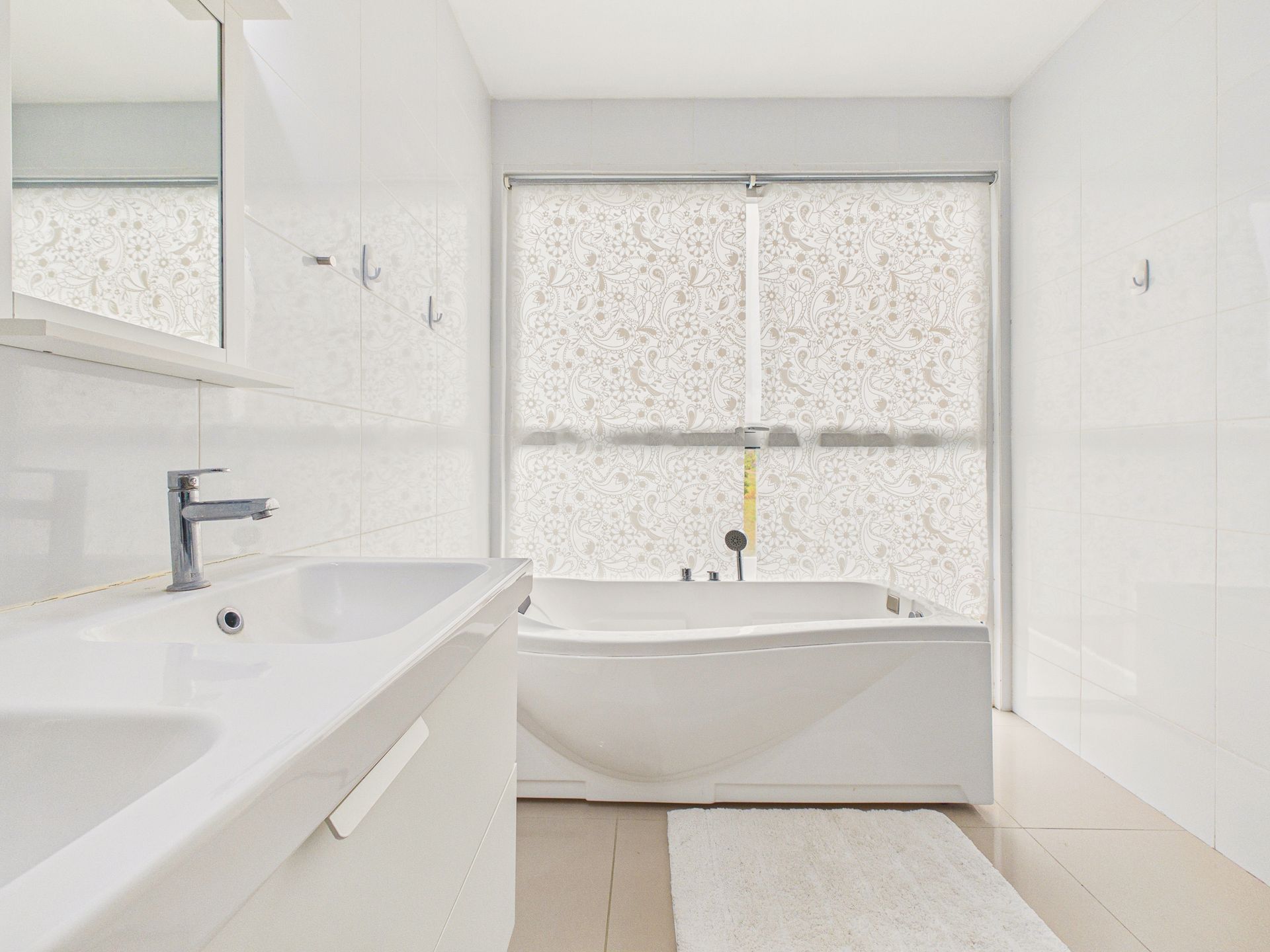 Baño moderno de color blanco con lavabo, bañera y ventana esmerilada.