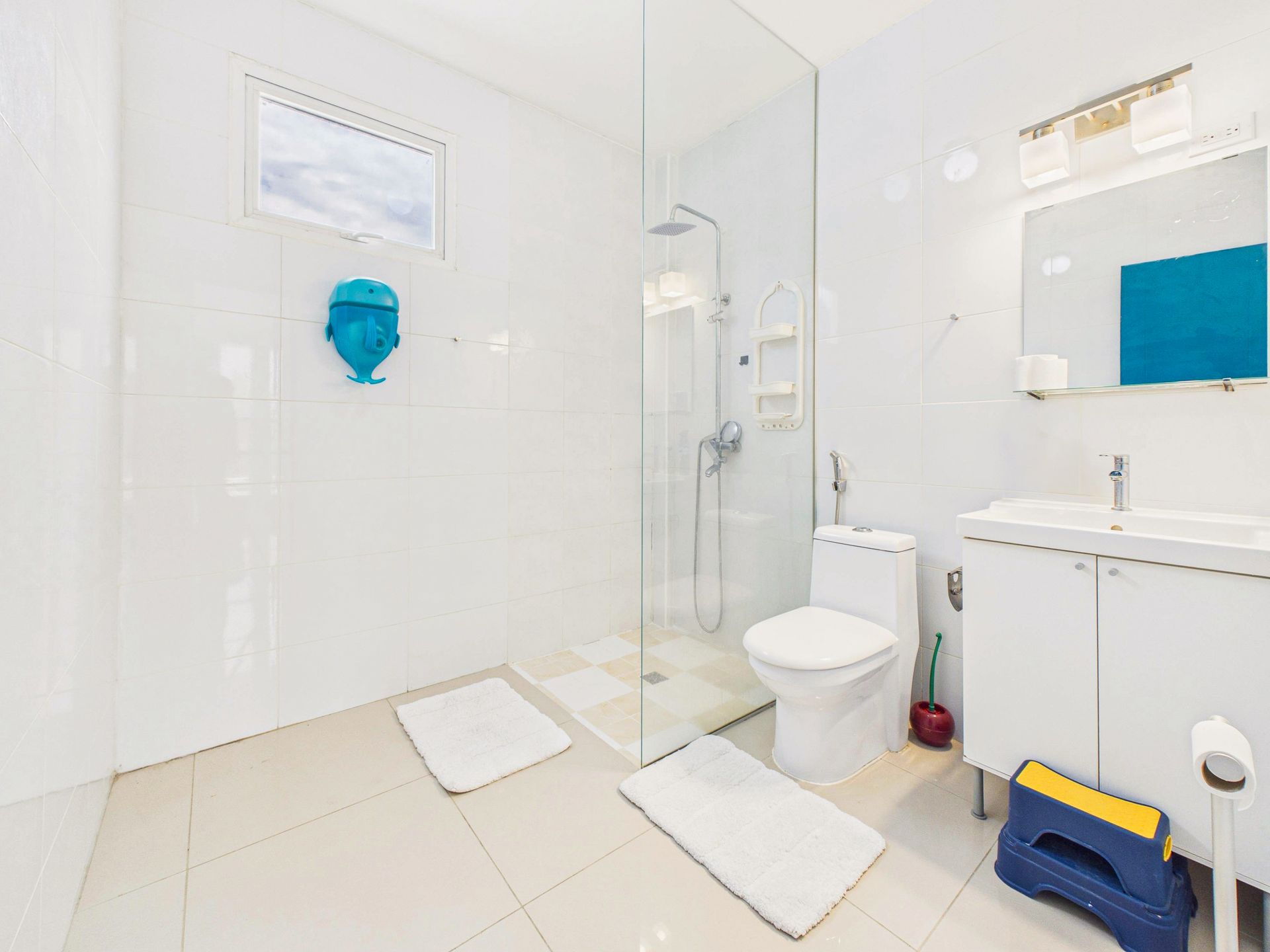 Baño blanco brillante con ducha, inodoro, lavabo, espejo y detalles azules.