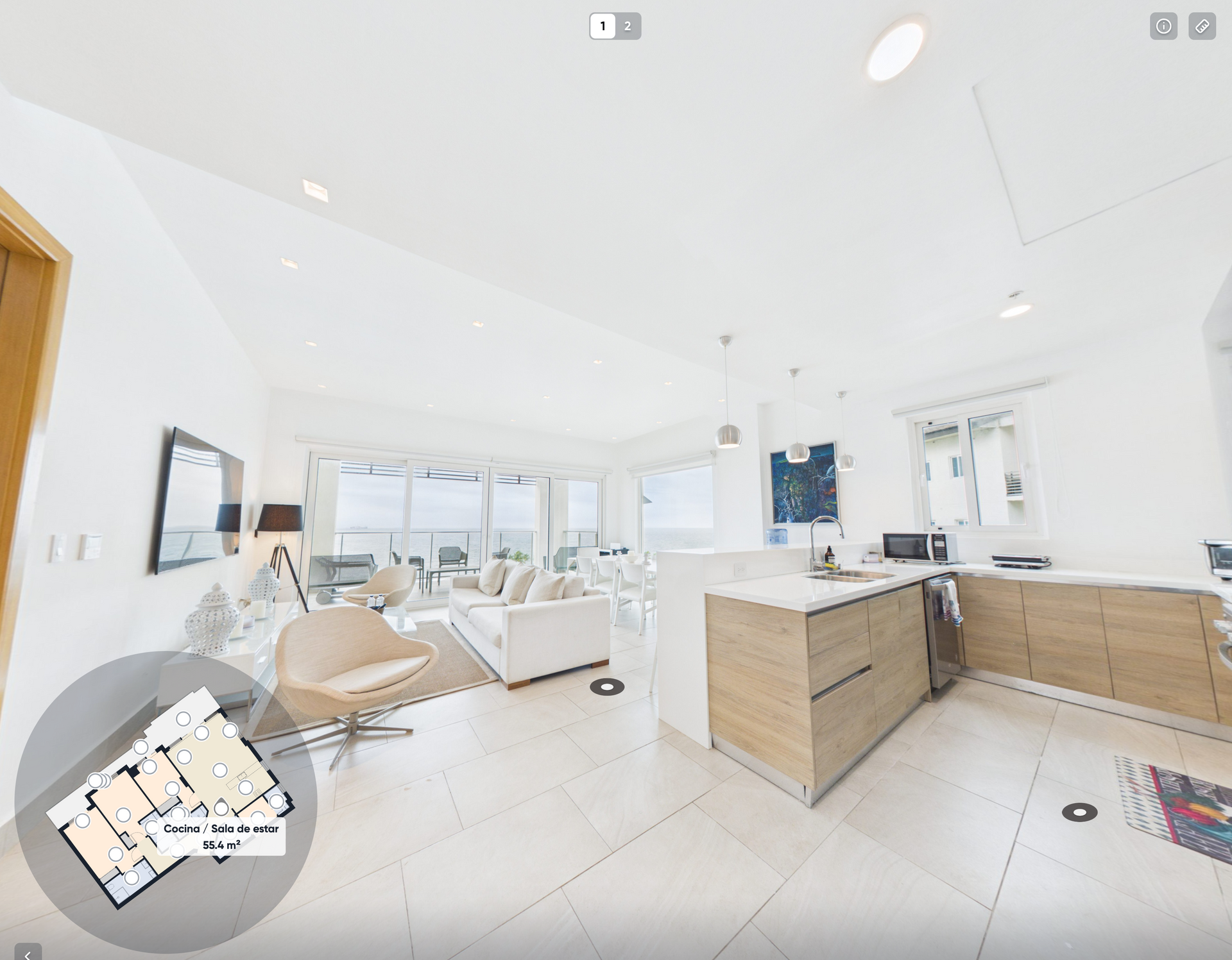 Salón-cocina luminoso y moderno de planta abierta con muebles blancos, armarios de madera y grandes ventanales.Playa escondida colon