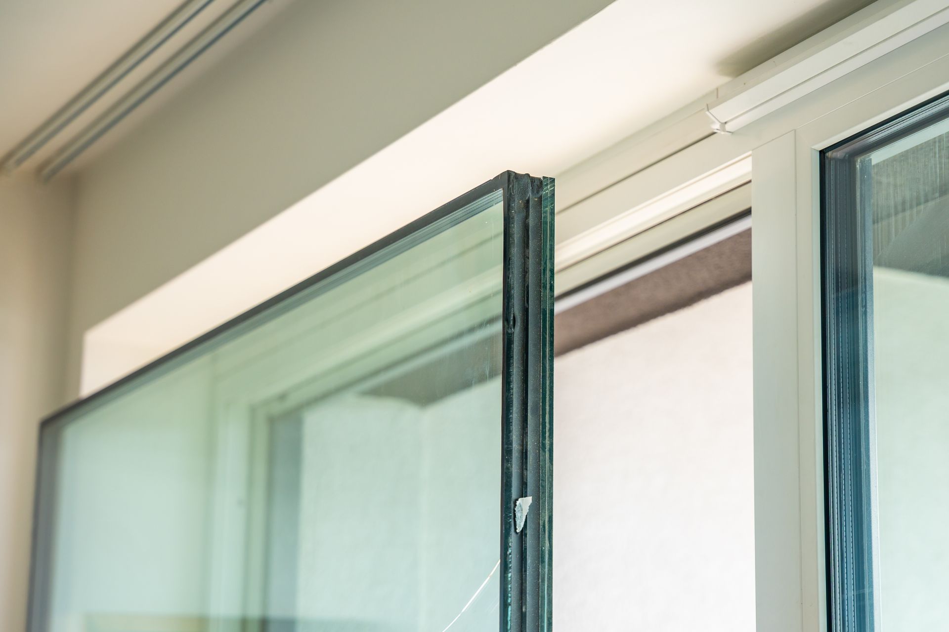 Open glass sliding doors with teal frames in a bright interior.