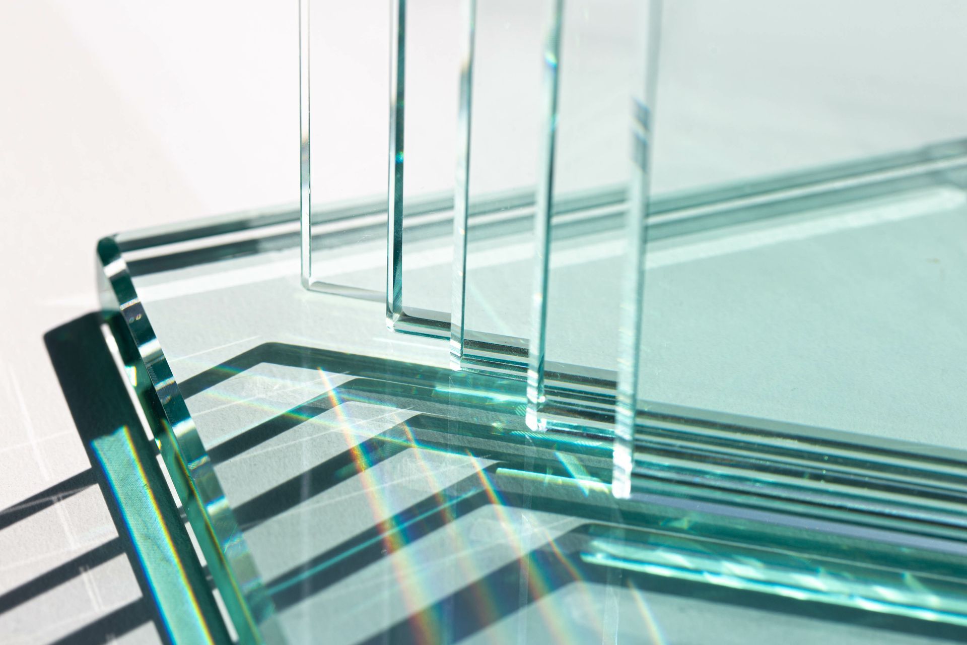 Glass staircase railing with clear panels and metal supports in a bright modern interior