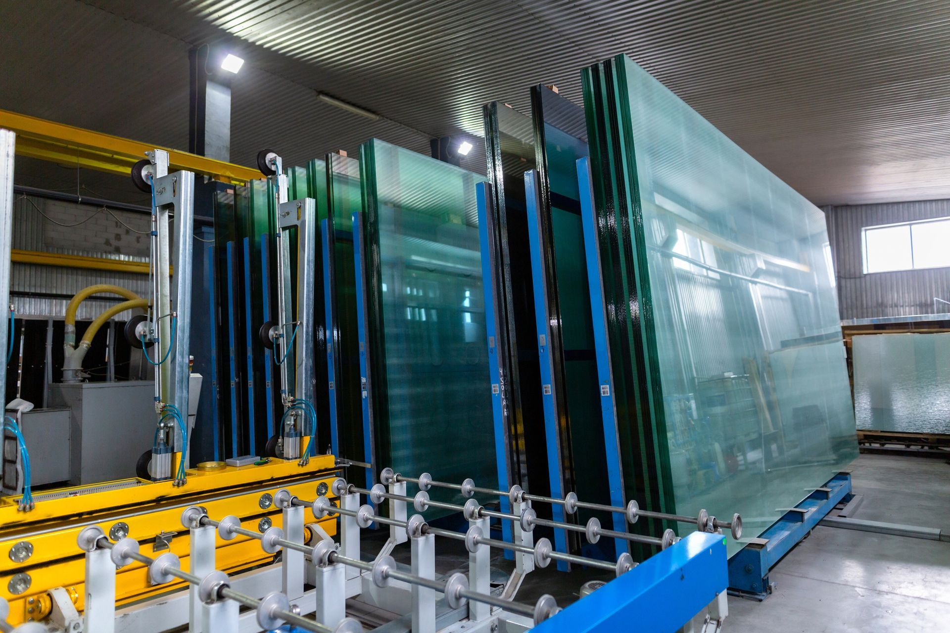 Glass panels being processed on an industrial production line in a factory
