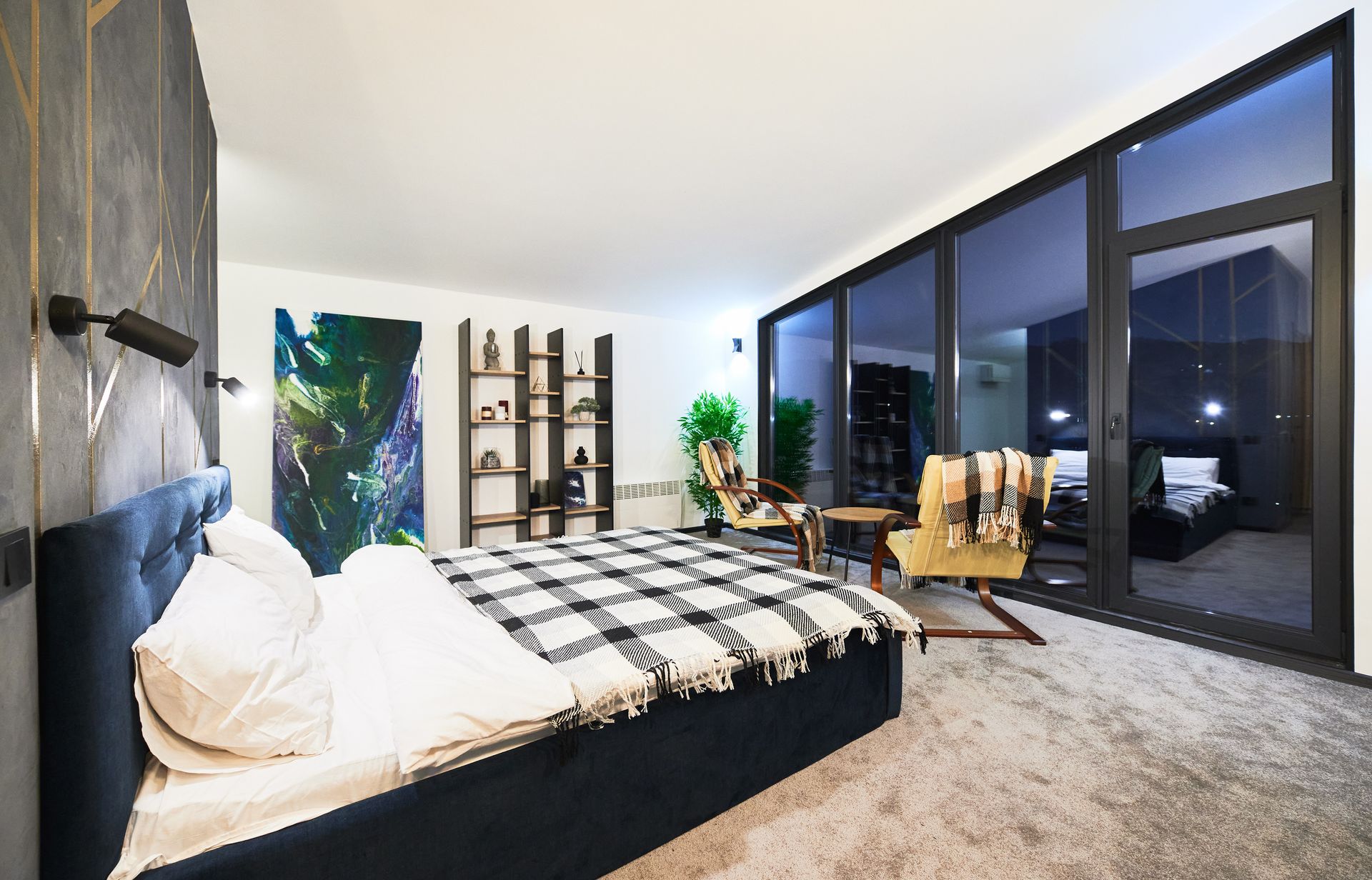 Modern bedroom with bed, shelves, and floor-to-ceiling windows at night