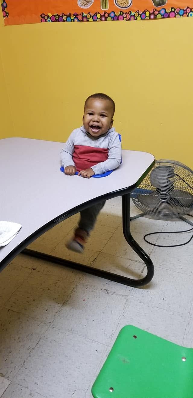 Smiling baby sitting at a classroom