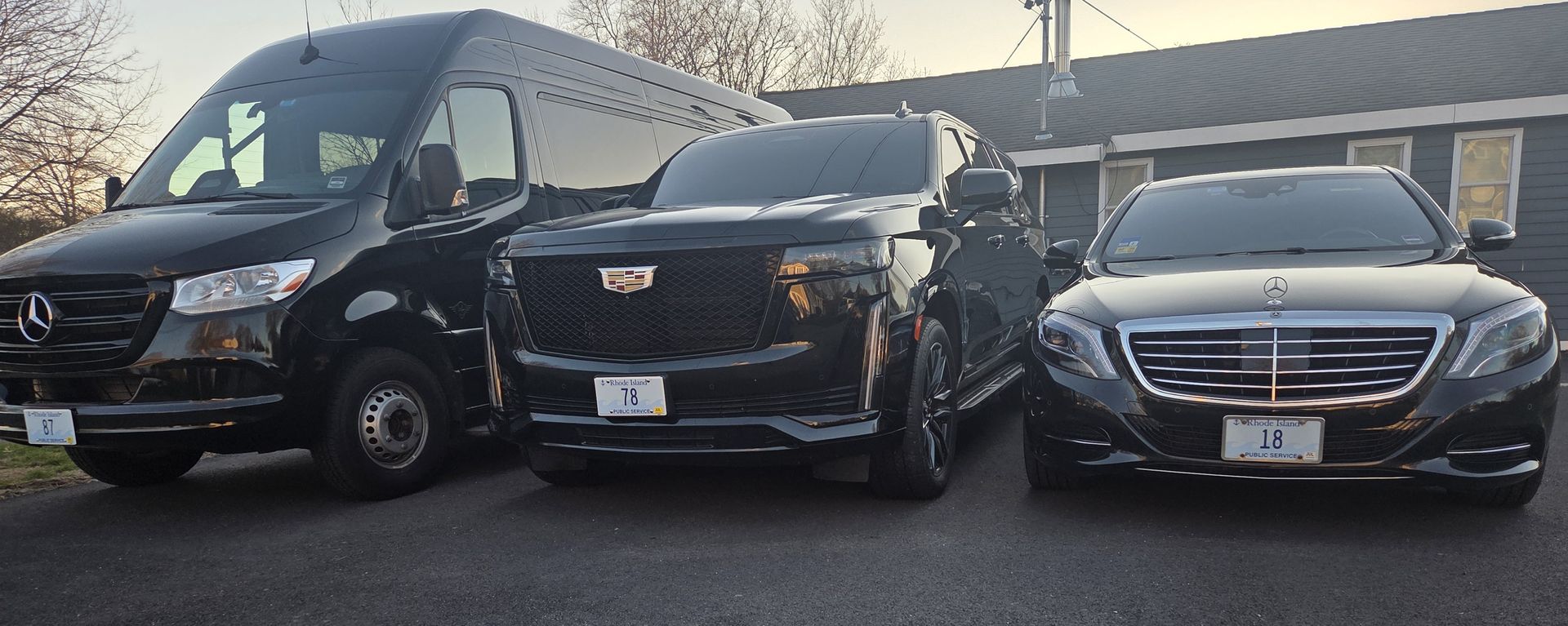 Three black SUVs parked side by side in a lot, front views visible.
