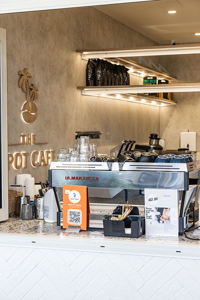 Cafe Counter With an Espresso Machine and Stacked Cups — JMB Electrical Services In Port Kembla, NSW