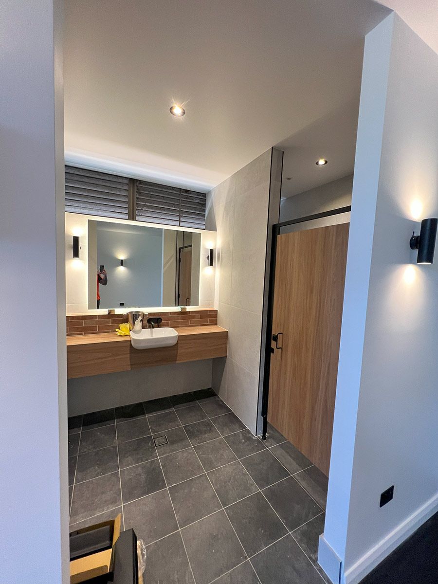 Modern Bathroom With Slate Tiles and a Wooden Vanity — JMB Electrical Services In Port Kembla, NSW