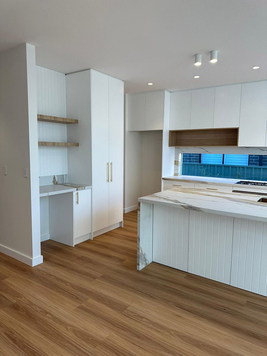 Kitchen With White Cabinets and Marble Countertops — JMB Electrical Services In Port Kembla, NSW