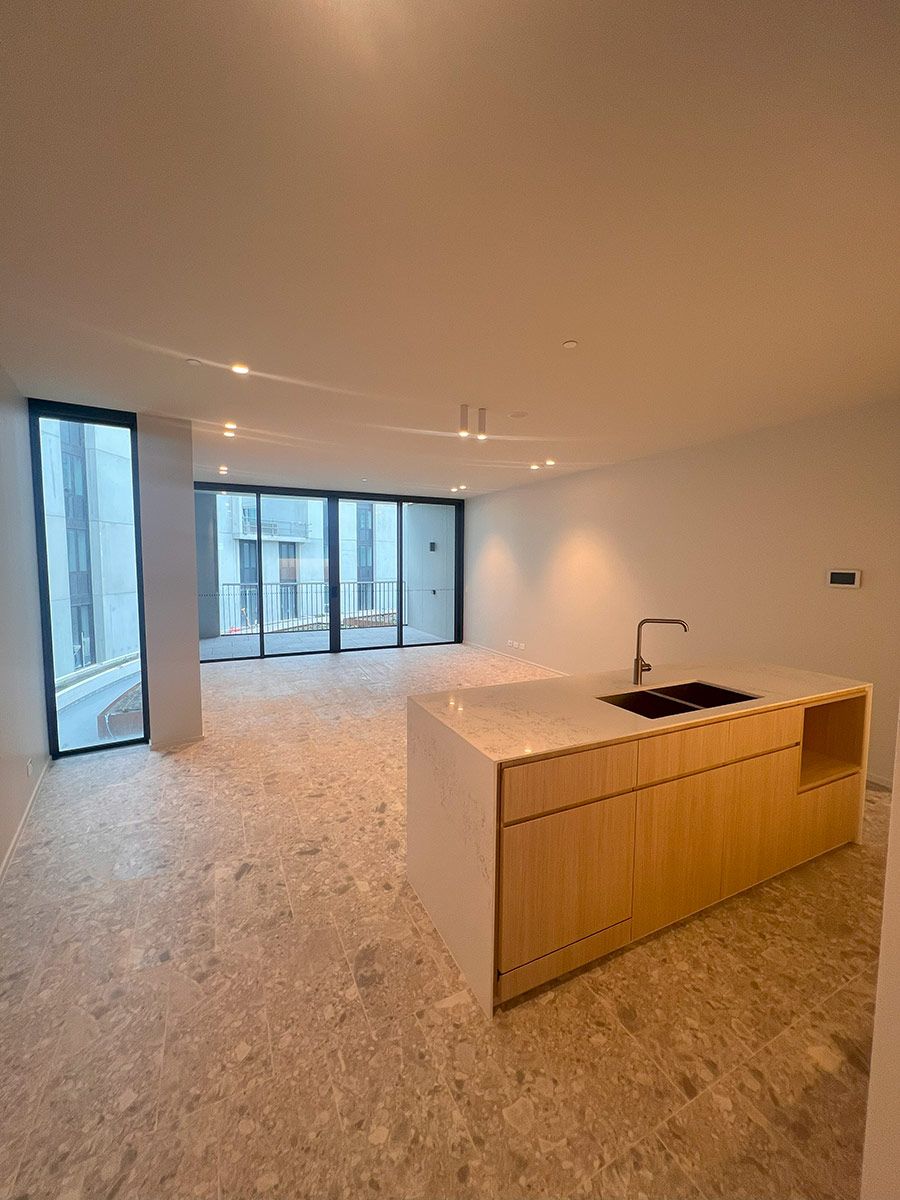 A Central Kitchen Island With a Wood Finish — JMB Electrical Services In Port Kembla, NSW