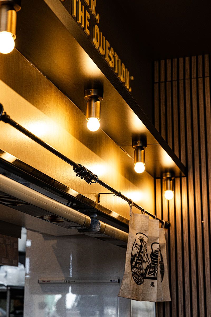 Warmly Lit Interior With Lightbulbs on a Dark Wooden Ceiling — JMB Electrical Services In Port Kembla, NSW