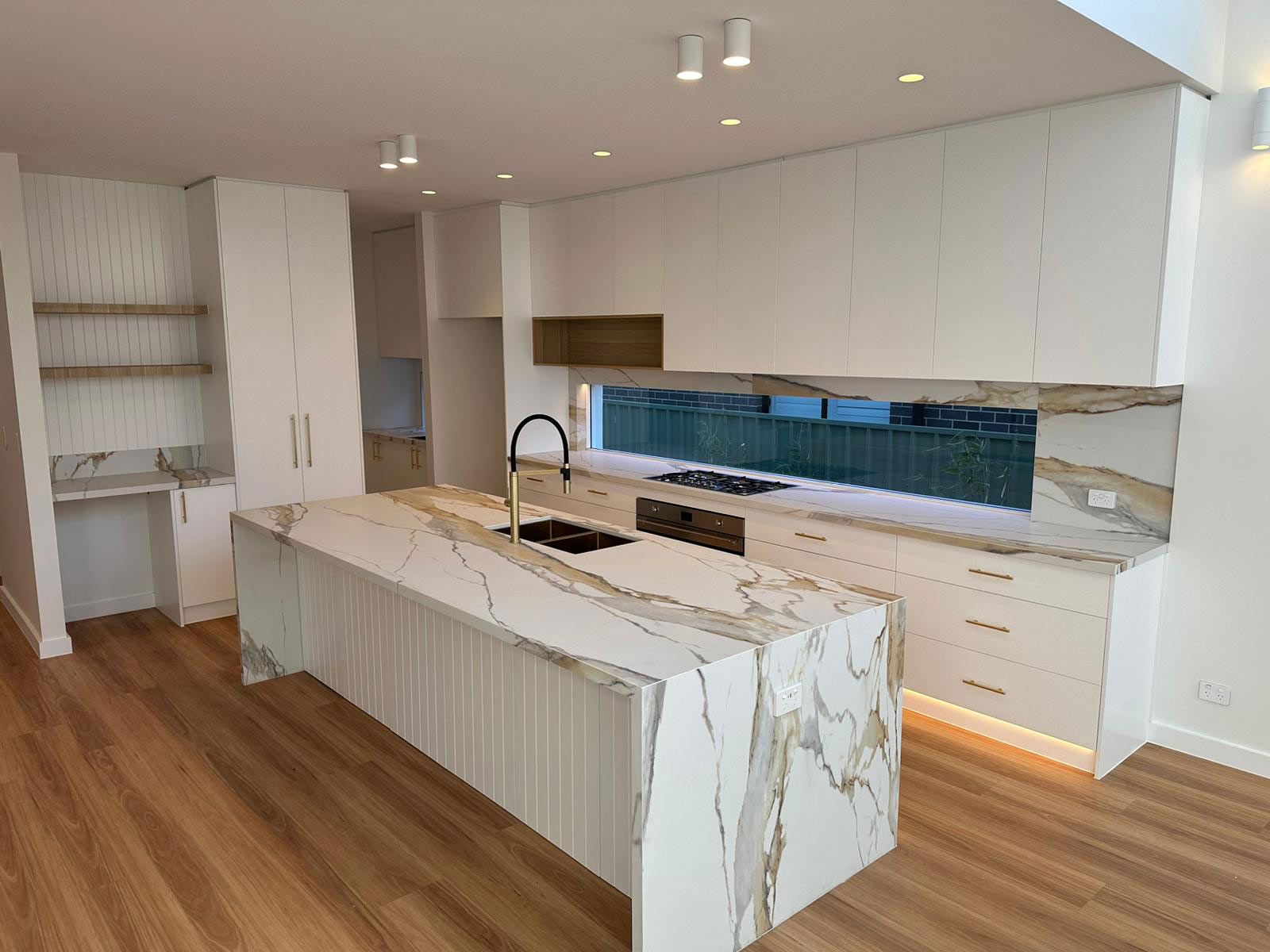 Kitchen With a Large Island Featuring a Black Faucet — JMB Electrical Services In Port Kembla, NSW