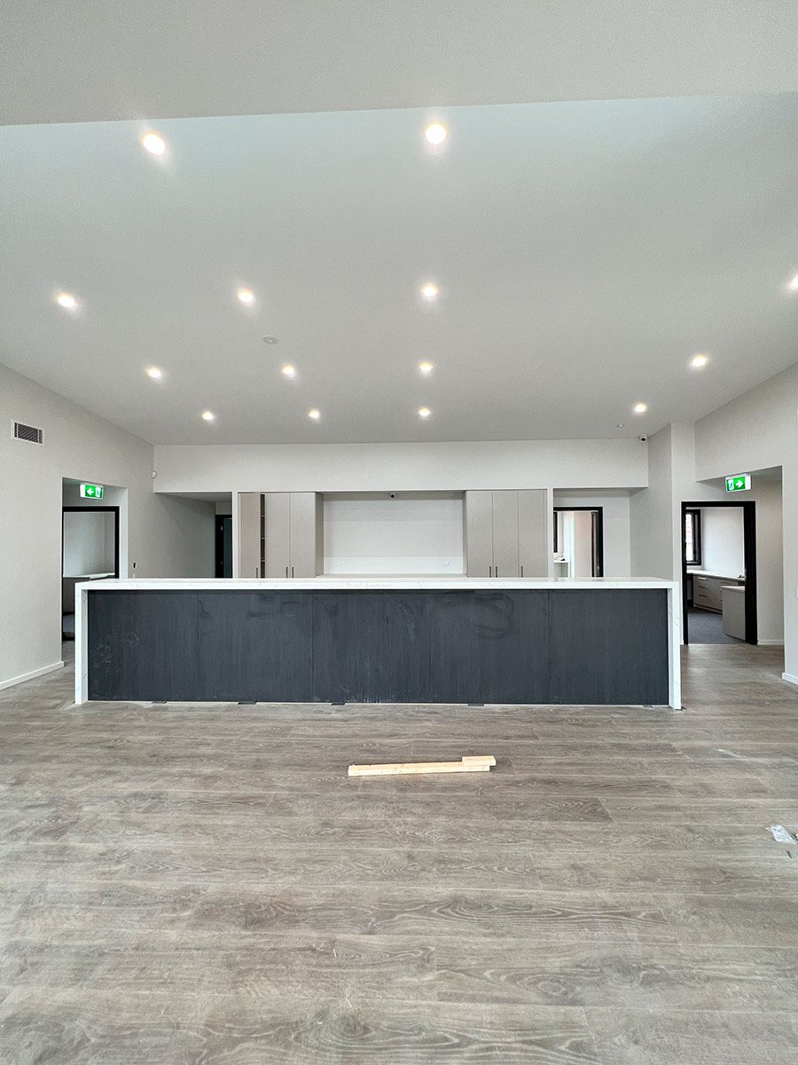 Modern Room With a Large Island and White Cabinets — JMB Electrical Services In Port Kembla, NSW
