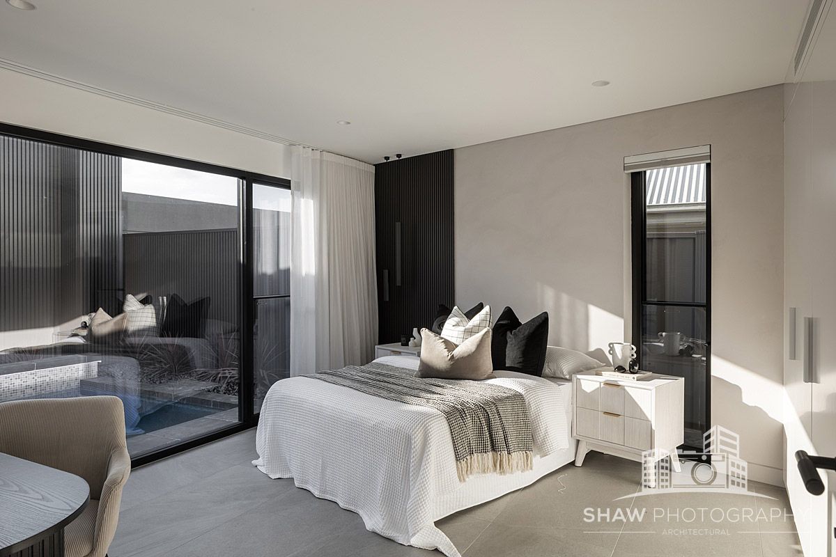 A Bedroom With a Large Bed and a Sliding Glass Door — JMB Electrical Services In Port Kembla, NSW