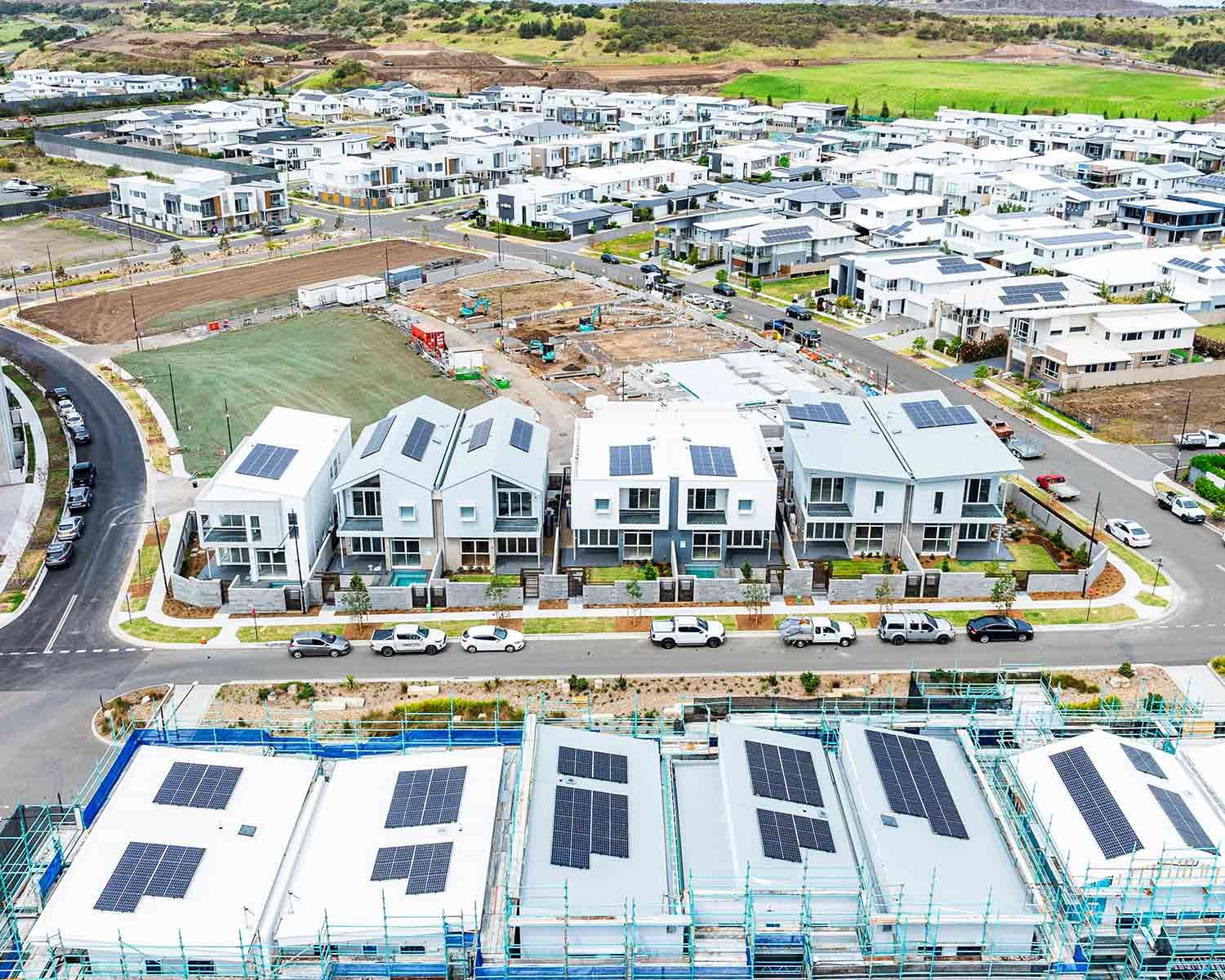 Modern Housing Development Featuring White Homes With Solar Panels — JMB Electrical Services In Port Kembla, NSW