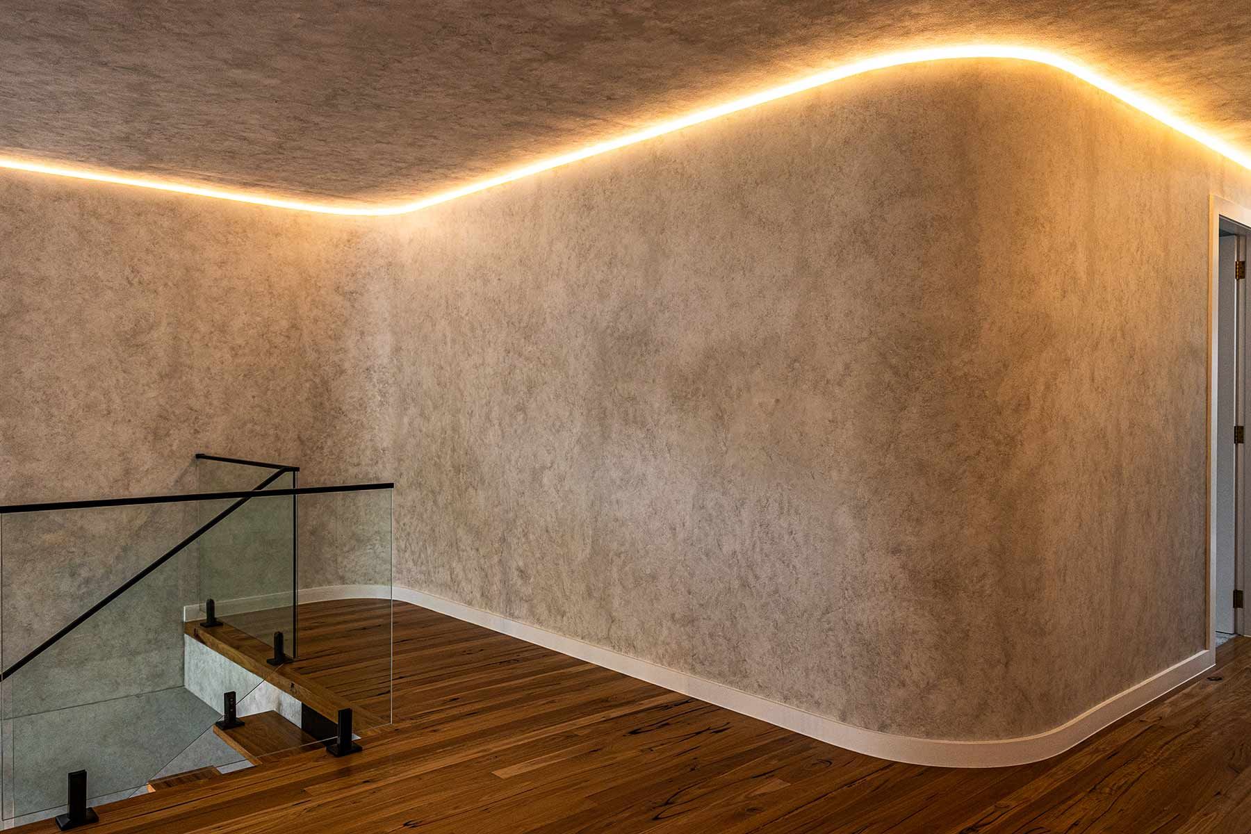 Hallway With Wooden Flooring and Textured Beige Walls — JMB Electrical Services In Port Kembla, NSW