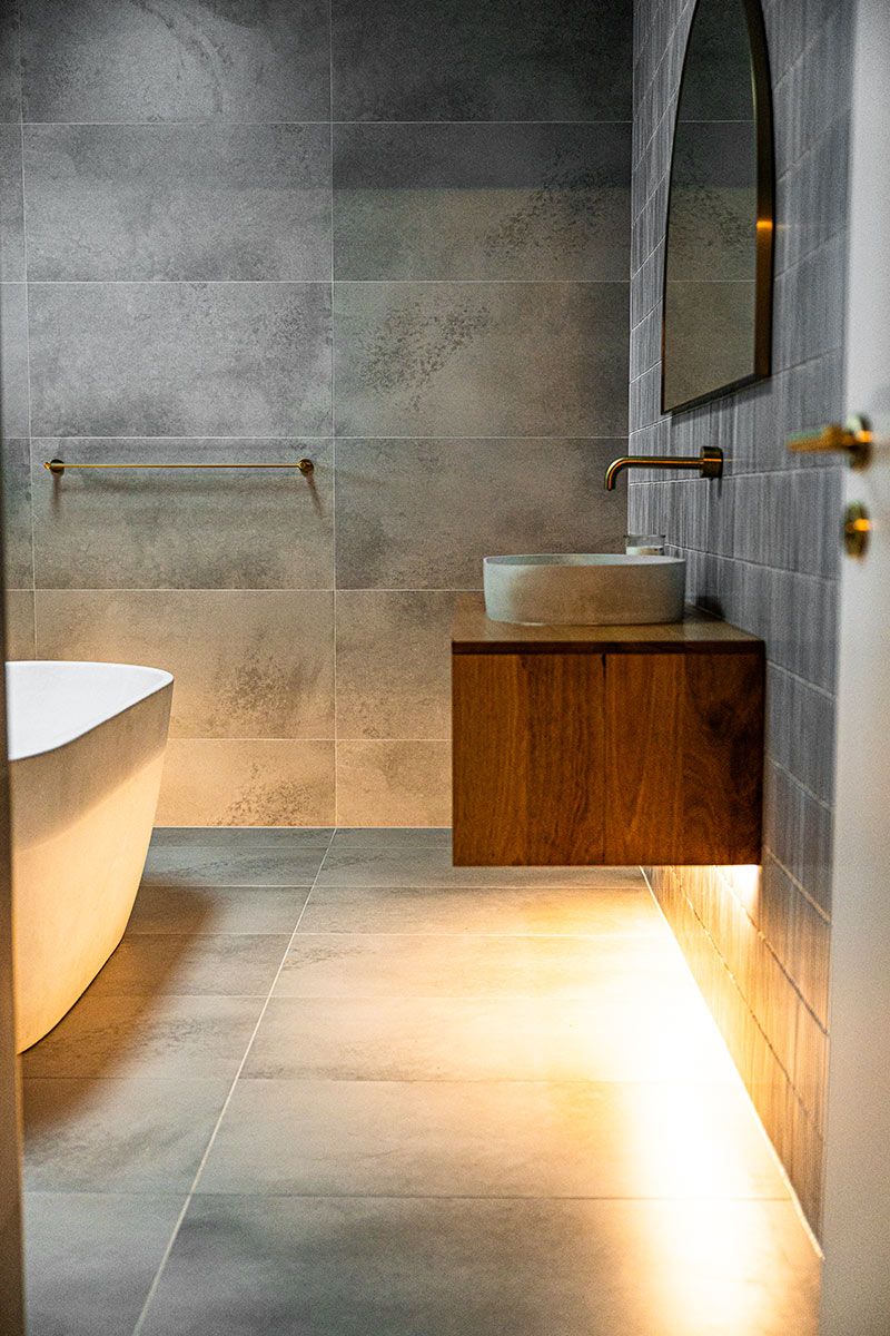 Modern Bathroom With a Freestanding Bathtub and a Floating Wooden Vanity — JMB Electrical Services In Port Kembla, NSW
