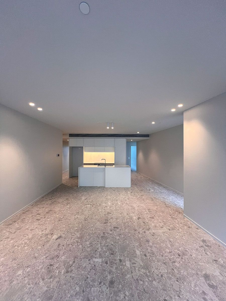 Spacious Kitchen With White Cabinets and a Central Island — JMB Electrical Services In Port Kembla, NSW