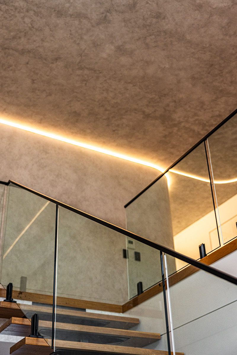 A Staircase With Wooden Steps and a Glass Railing — JMB Electrical Services In Port Kembla, NSW