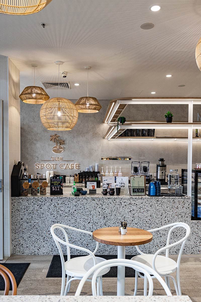 Cafe Interior Featuring White Chairs Around Wooden Tables — JMB Electrical Services In Port Kembla, NSW