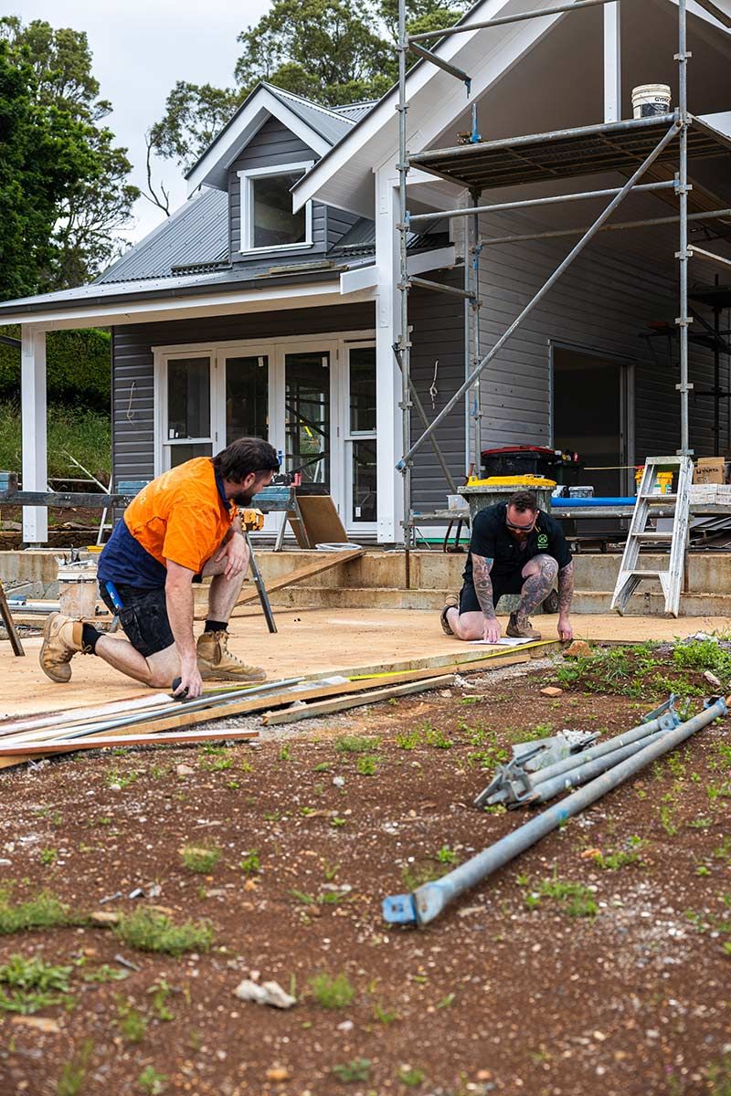 Two Construction Workers Are Focused on Building a Wooden Deck — JMB Electrical Services In Port Kembla, NSW