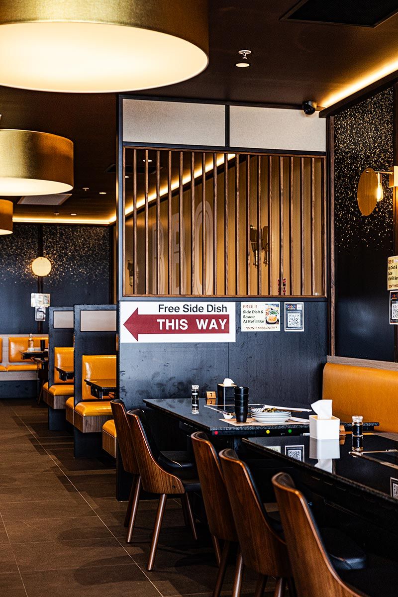 Restaurant Interior With Wooden Tables and Orange Booths — JMB Electrical Services In Port Kembla, NSW