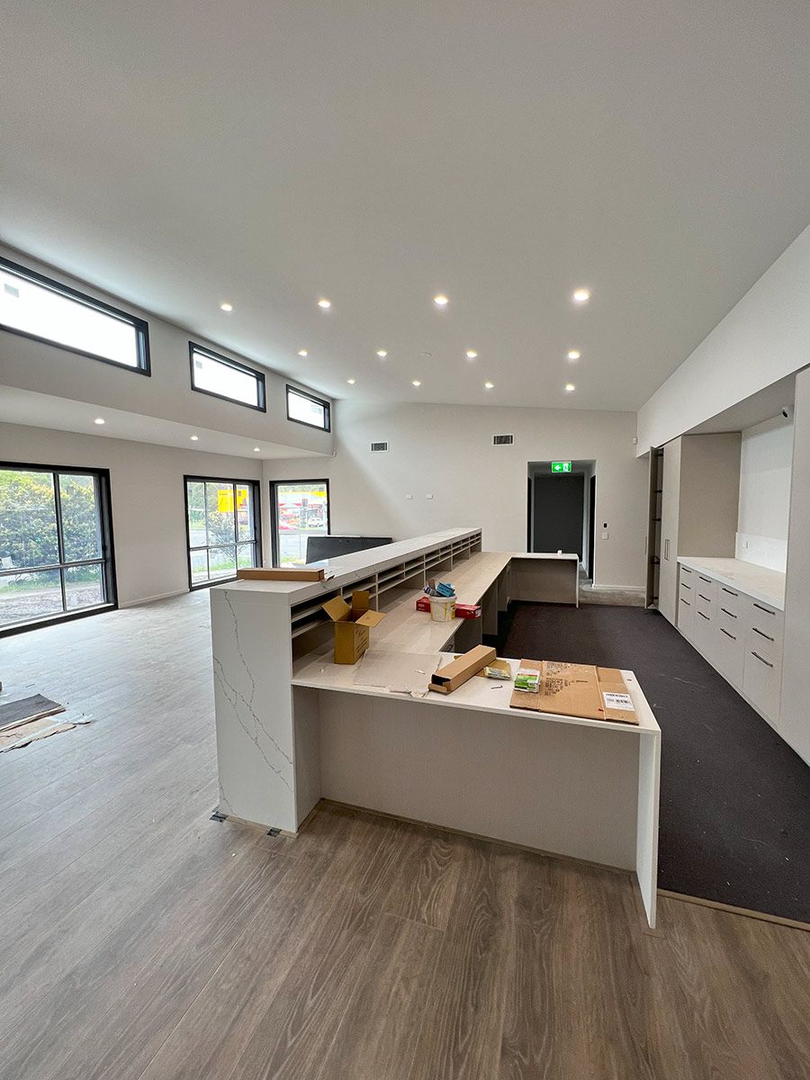 Modern Interior With Wooden Floors, White Cabinets, and a Central Counter — JMB Electrical Services In Port Kembla, NSW