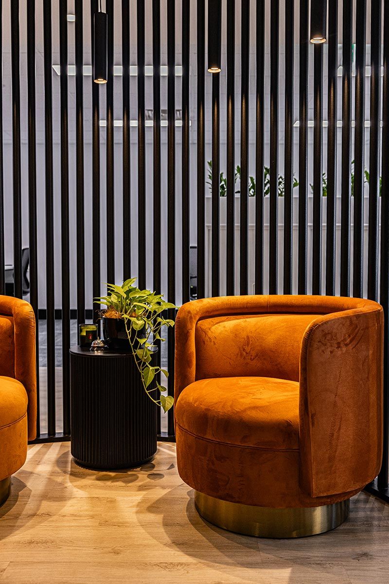 Two Orange Chairs Sit on a Wooden Floor — JMB Electrical Services In Port Kembla, NSW