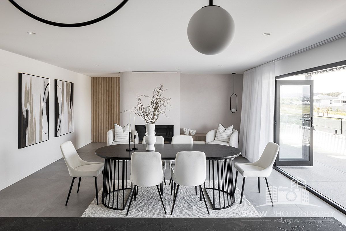 A Dining Room With a Round Table and White Chairs — JMB Electrical Services In Port Kembla, NSW