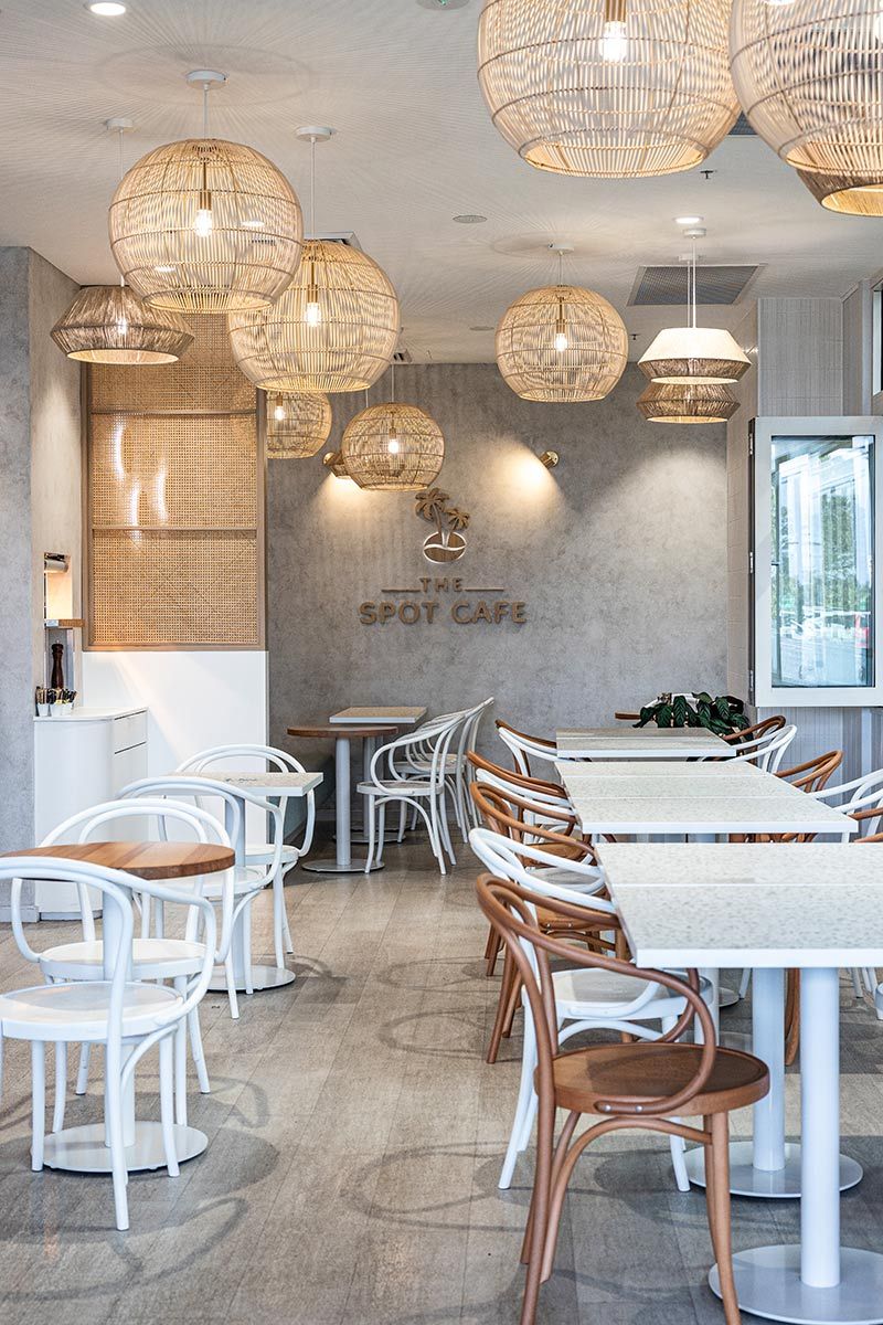 Modern Cafe Interior With Wooden Chairs and White Tables — JMB Electrical Services In Port Kembla, NSW
