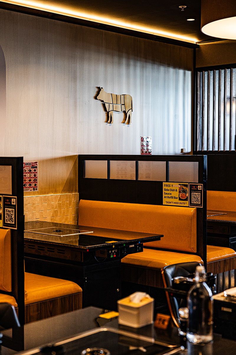 Cozy Restaurant Booth With a Cow Silhouette Art Piece on the Wall — JMB Electrical Services In Port Kembla, NSW